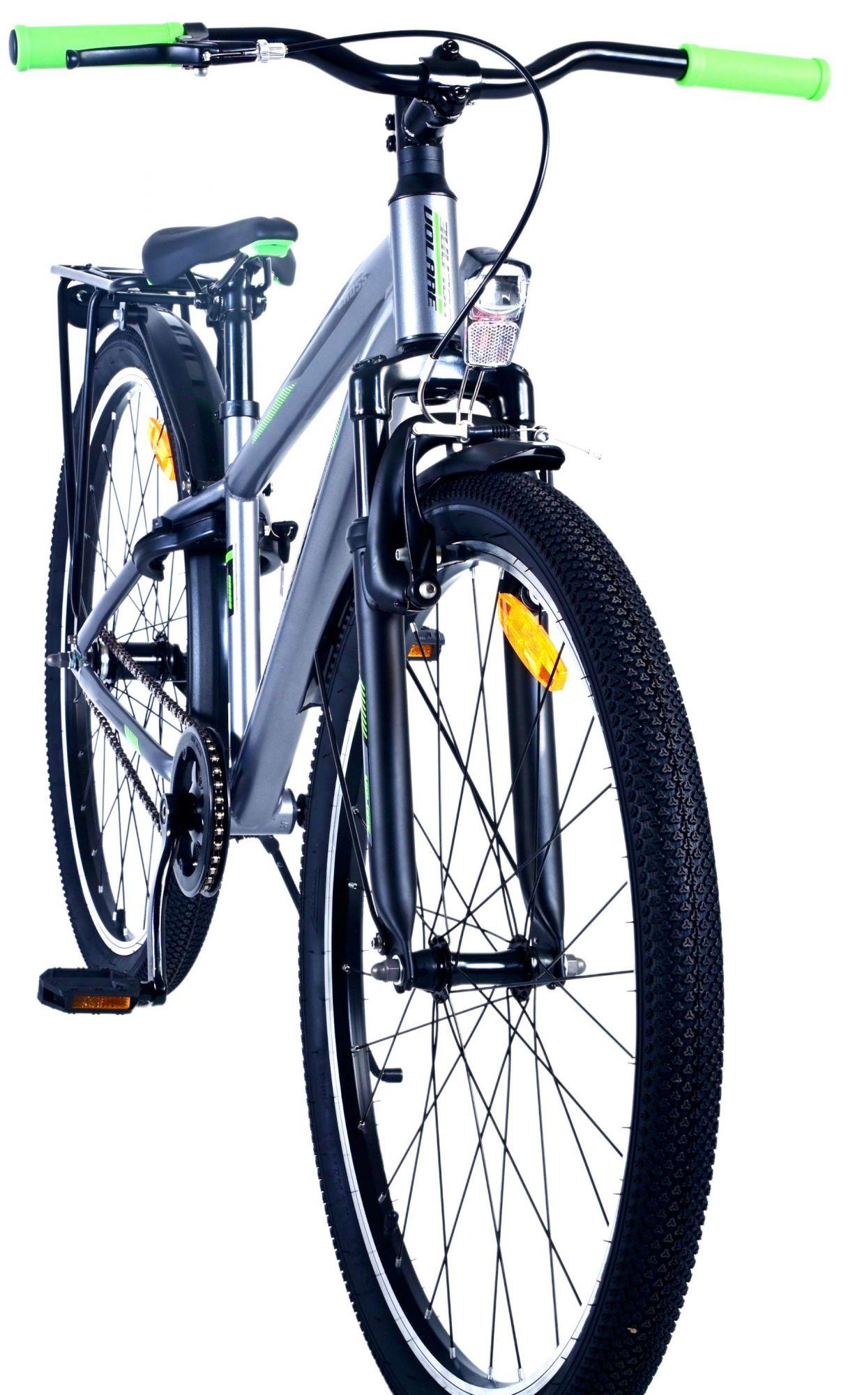 Ein silbernes Fahrrad mit grünen Griffen, nach vorne gerichtet. Es hat schwarze Reifen.