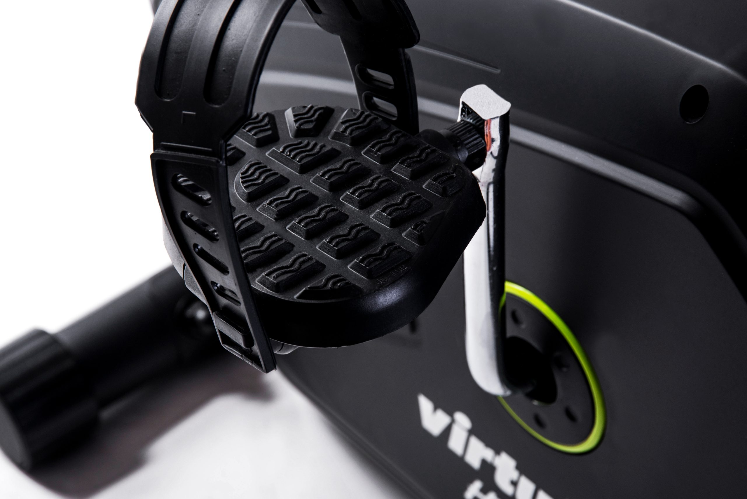 Nahaufnahme eines schwarzen Trainingsfahrradpedals. Das Pedal hat eine strukturierte Oberfläche und einen Riemen. Der Hintergrund ist weiß.