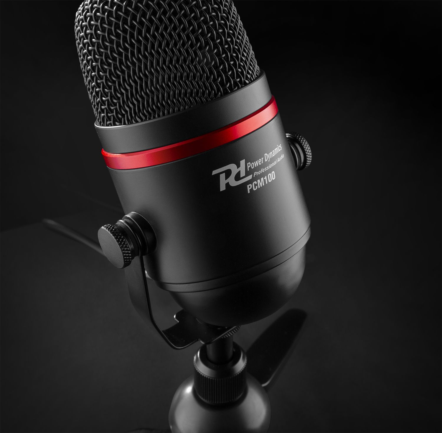 Un micrófono negro con un anillo rojo y el texto 'Power Dynamics'.