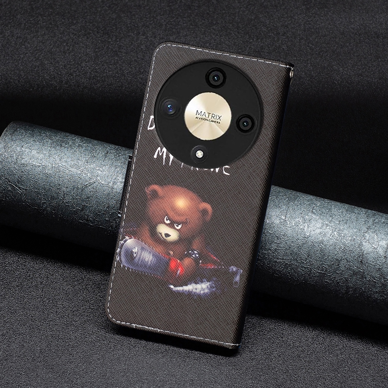 Handyhülle mit Teddybär-Design. Die Hülle ist braun mit dunklem Hintergrund. Kamera sichtbar.