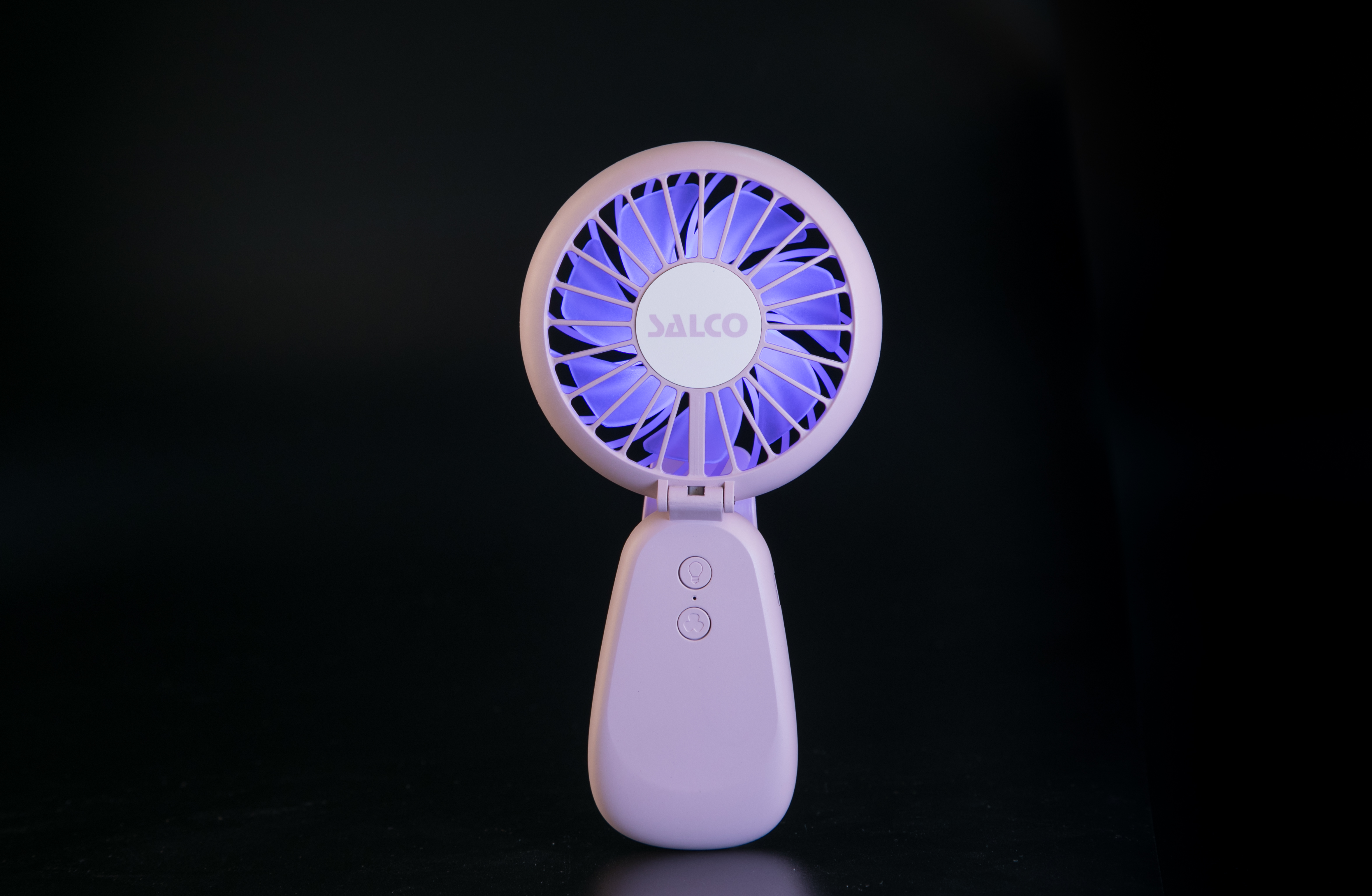 Ein rosa Handventilator mit blauem Licht von innen. Der Ventilator hat das 'SALCO' Logo.