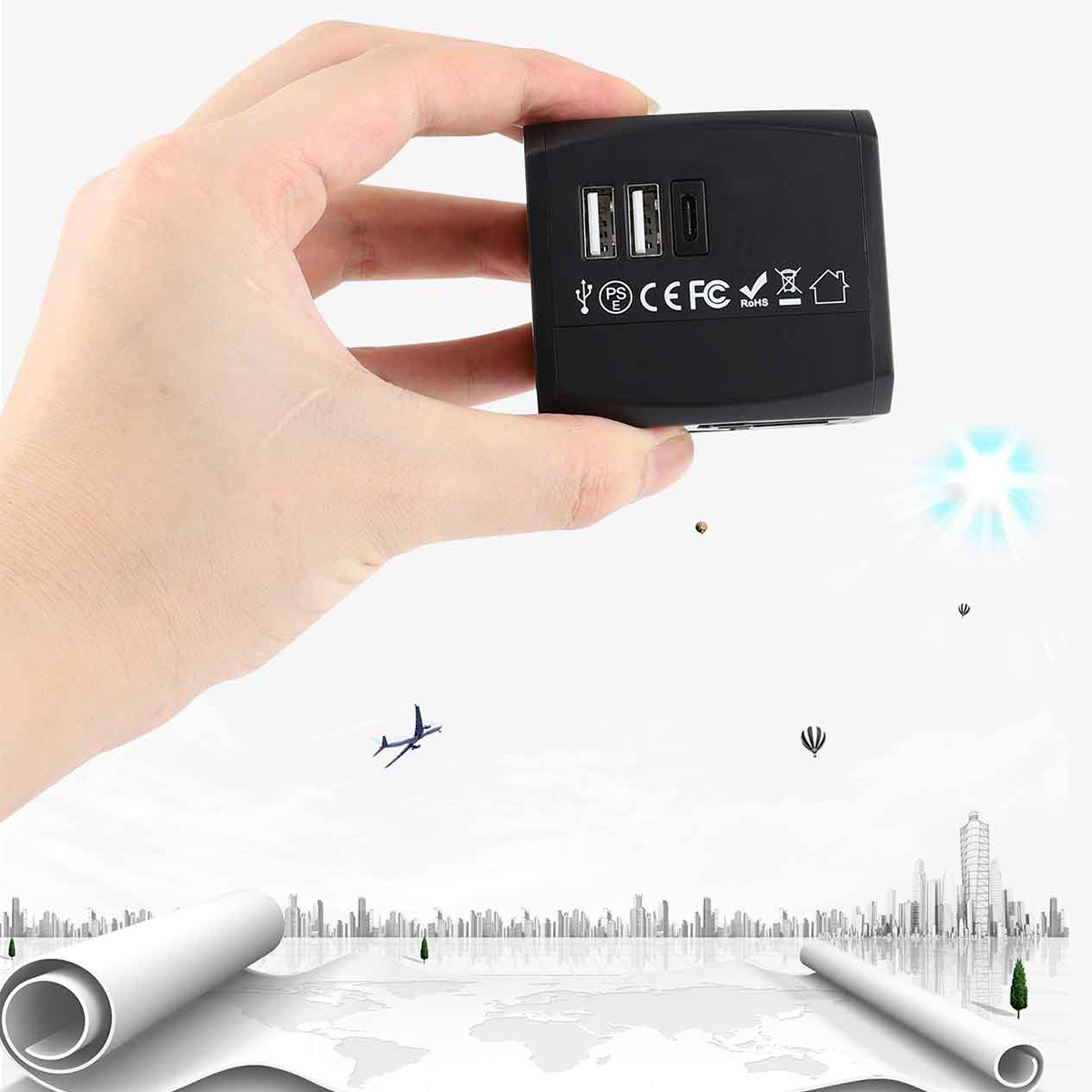 Hand hält schwarzen Reiseadapter mit USB-Anschlüssen, Weltkartenhintergrund.