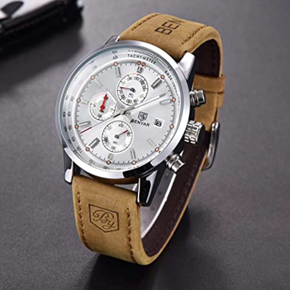 Eine silberne und beige Benyar-Uhr mit Lederarmband auf dunkler Oberfläche.