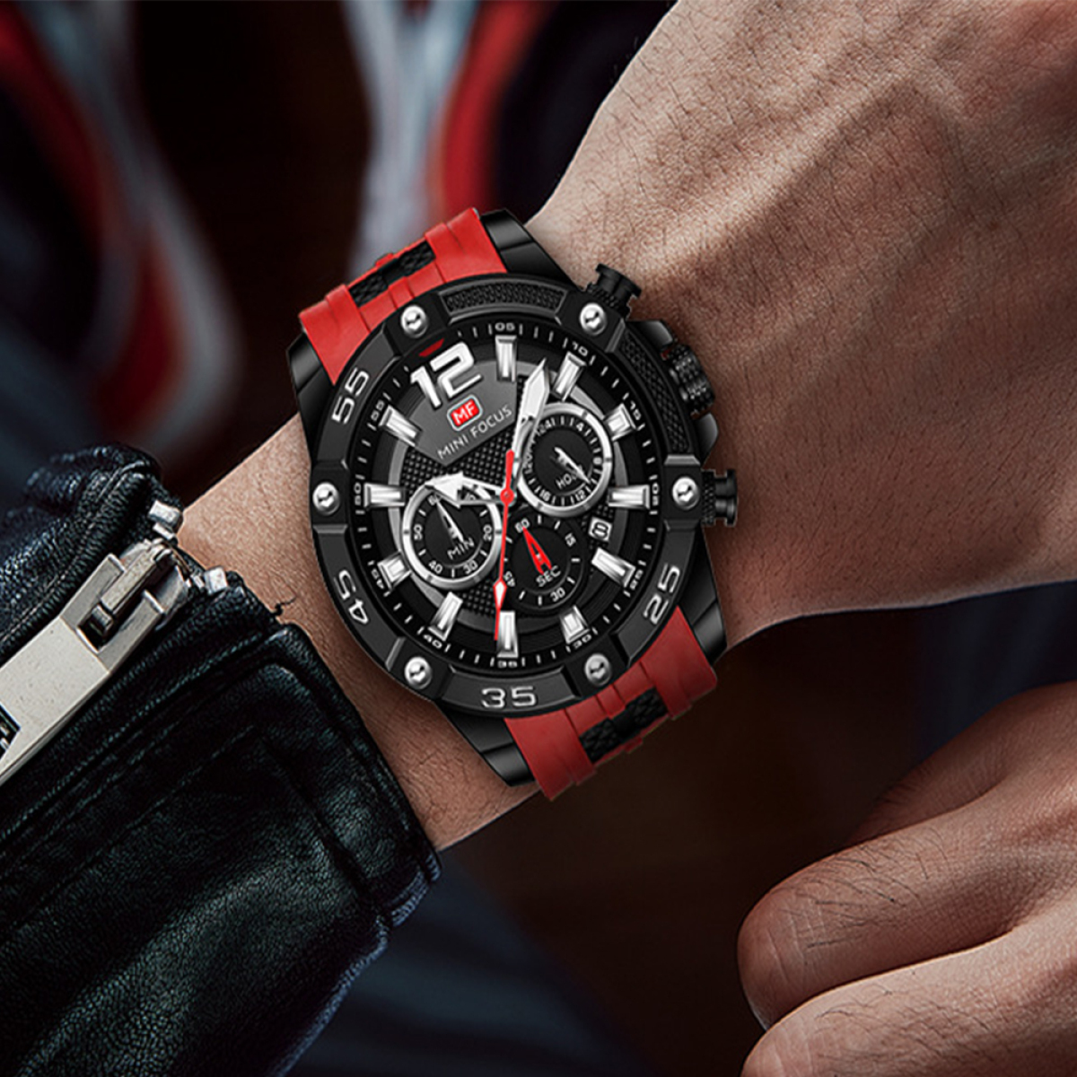 Schwarze Uhr mit roten Akzenten am Handgelenk. Die Uhr hat ein schwarz-rotes Armband.