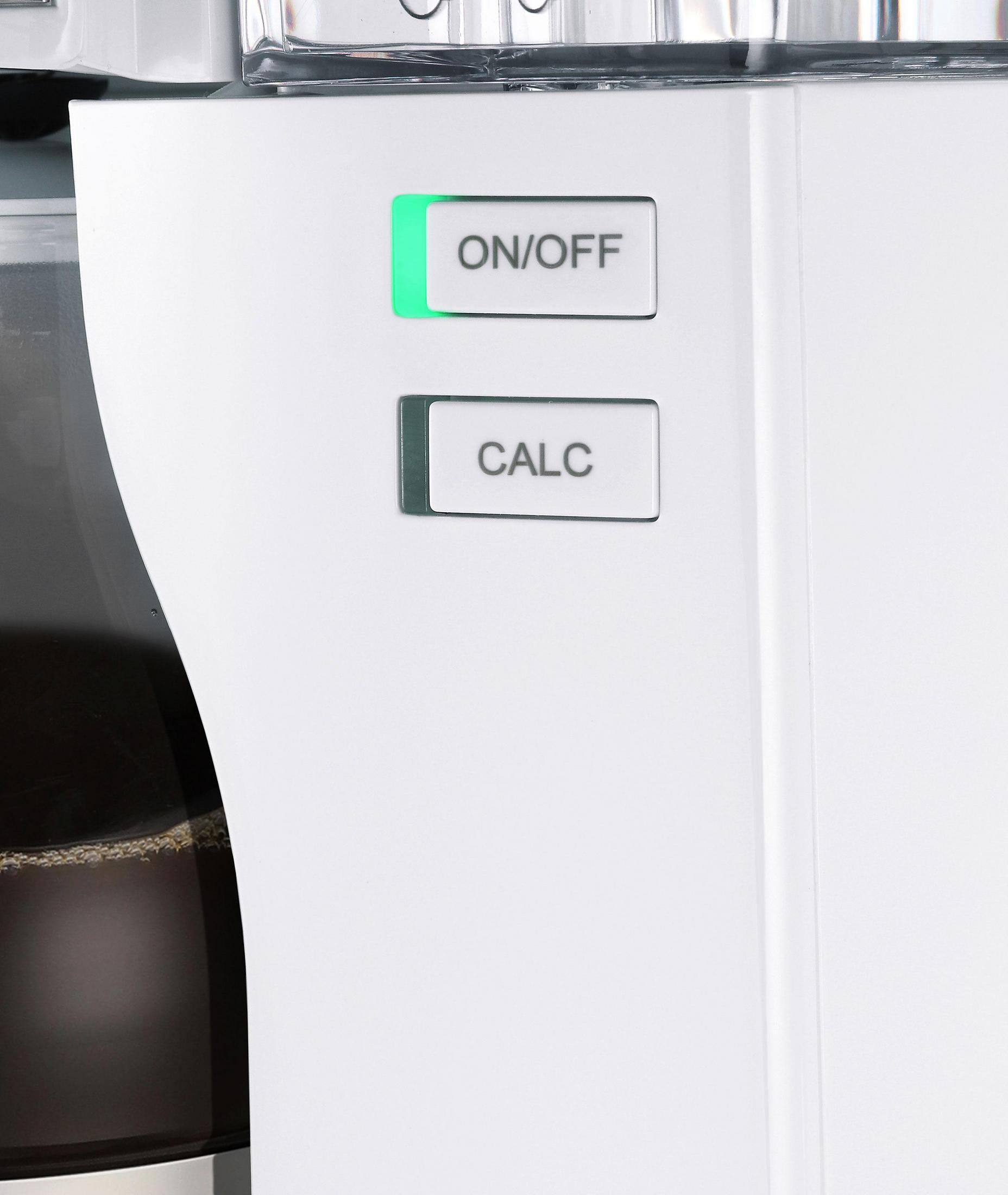 Biały ekspres do kawy z przyciskami włącz/wyłącz i kalkulacji, świeci zielone światło.