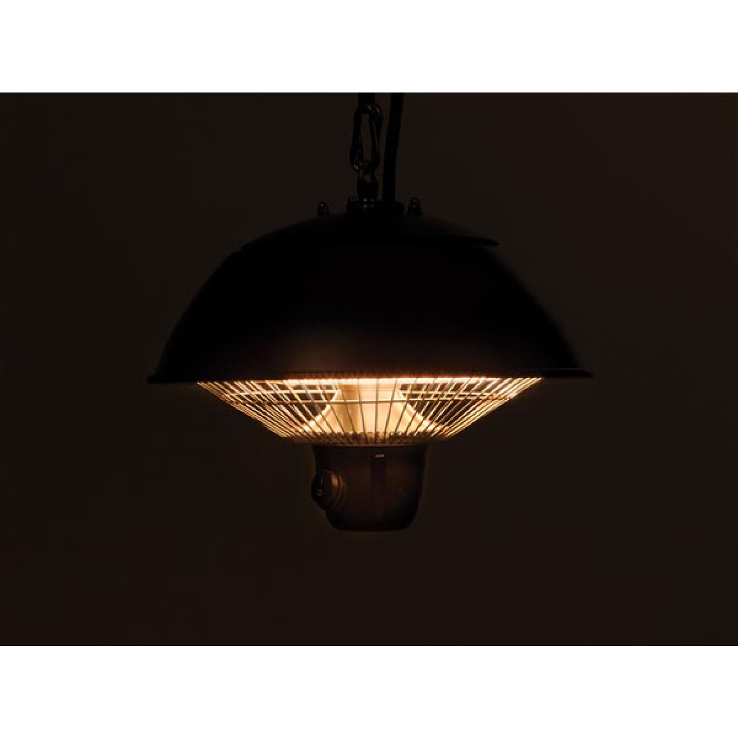 Un calefactor colgante negro, iluminado con una luz cálida. Fondo oscuro.