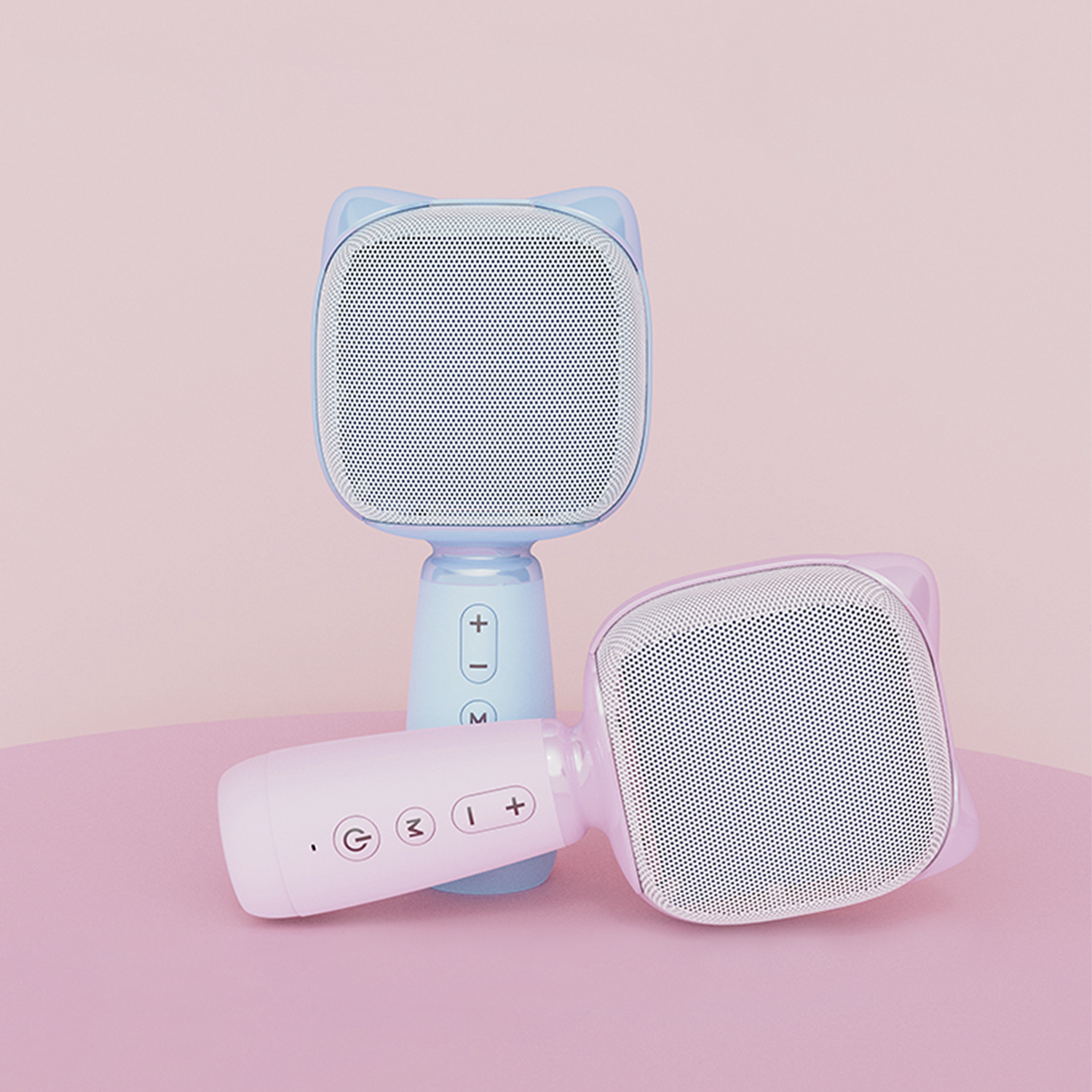 Due microfoni rosa e blu a forma di orecchie di gatto su una superficie rosa.
