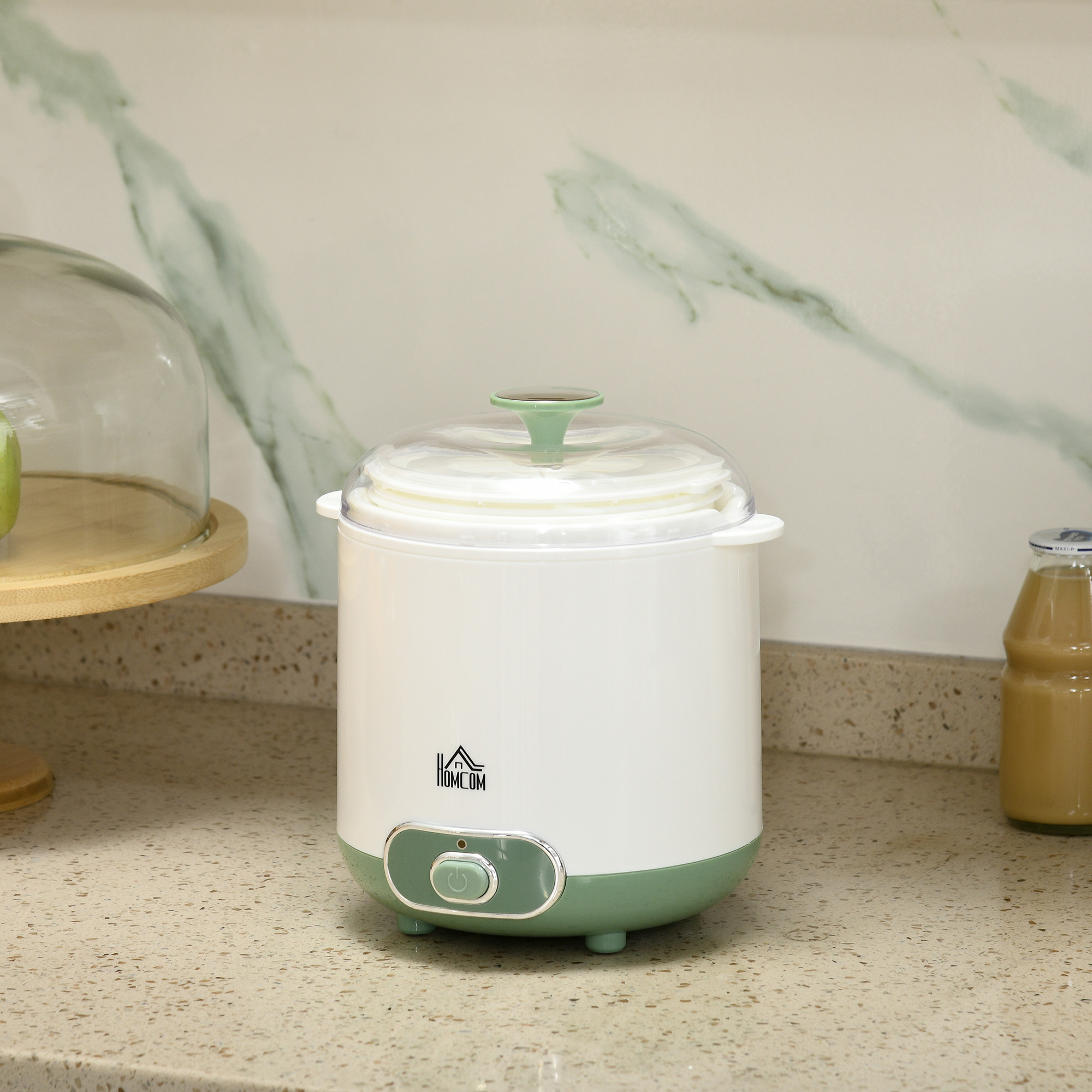 Hacedor de alimentos para bebés blanco y verde en una encimera de cocina.