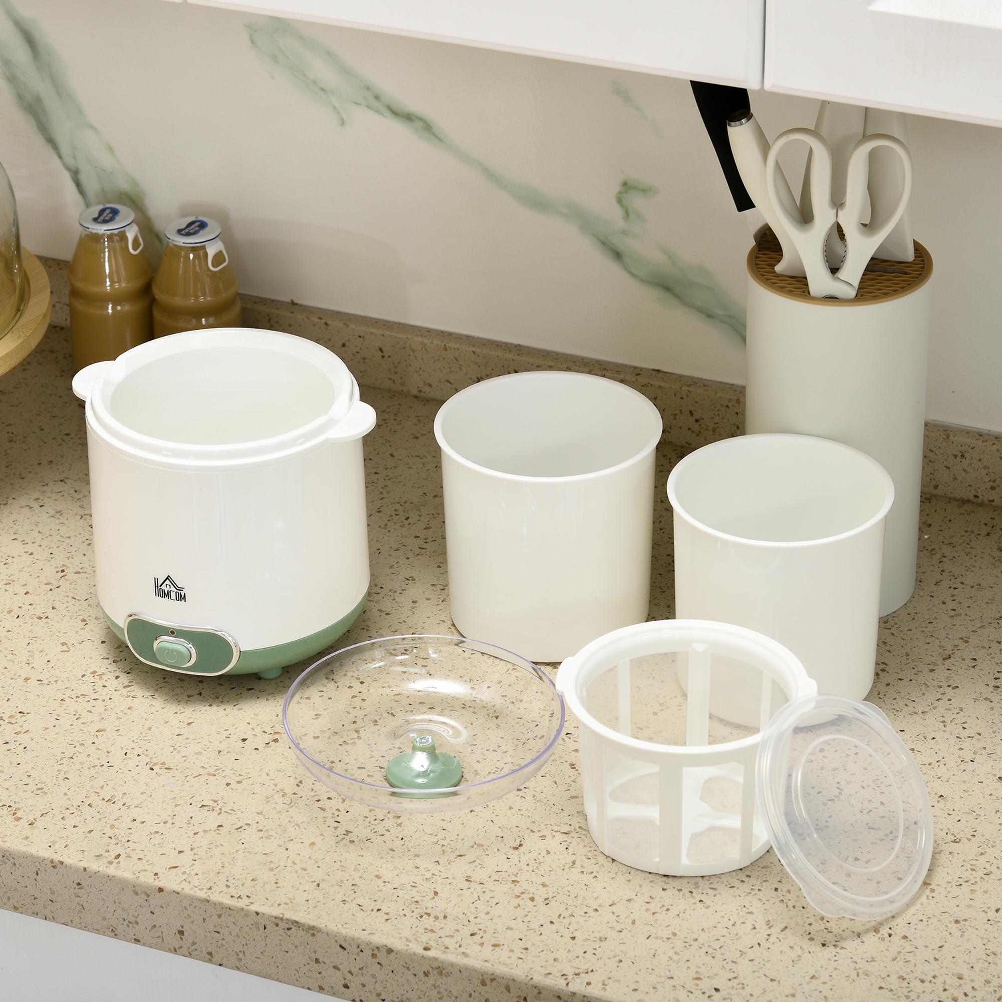Encimera de cocina con recipientes. Contenedores blancos con un cuenco transparente y una base verde.