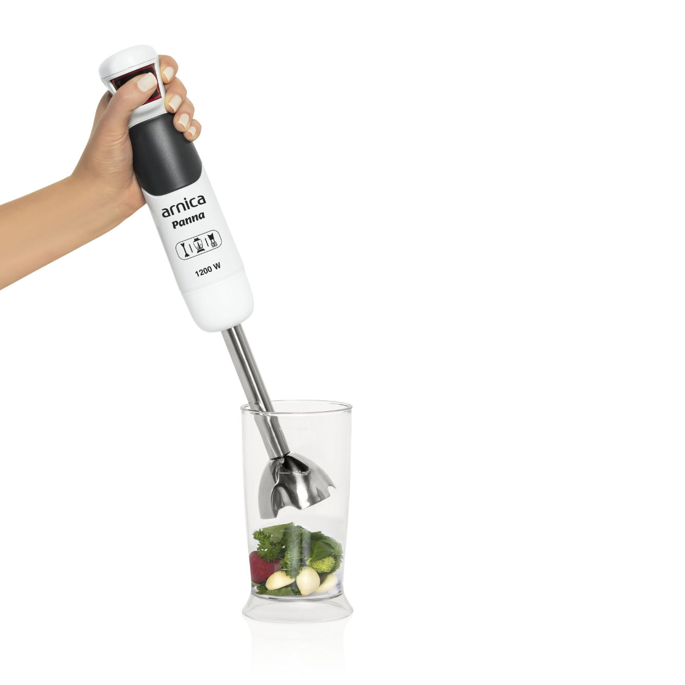 Hand, die einen weißen und schwarzen Stabmixer über einem Glas mit Zutaten hält.