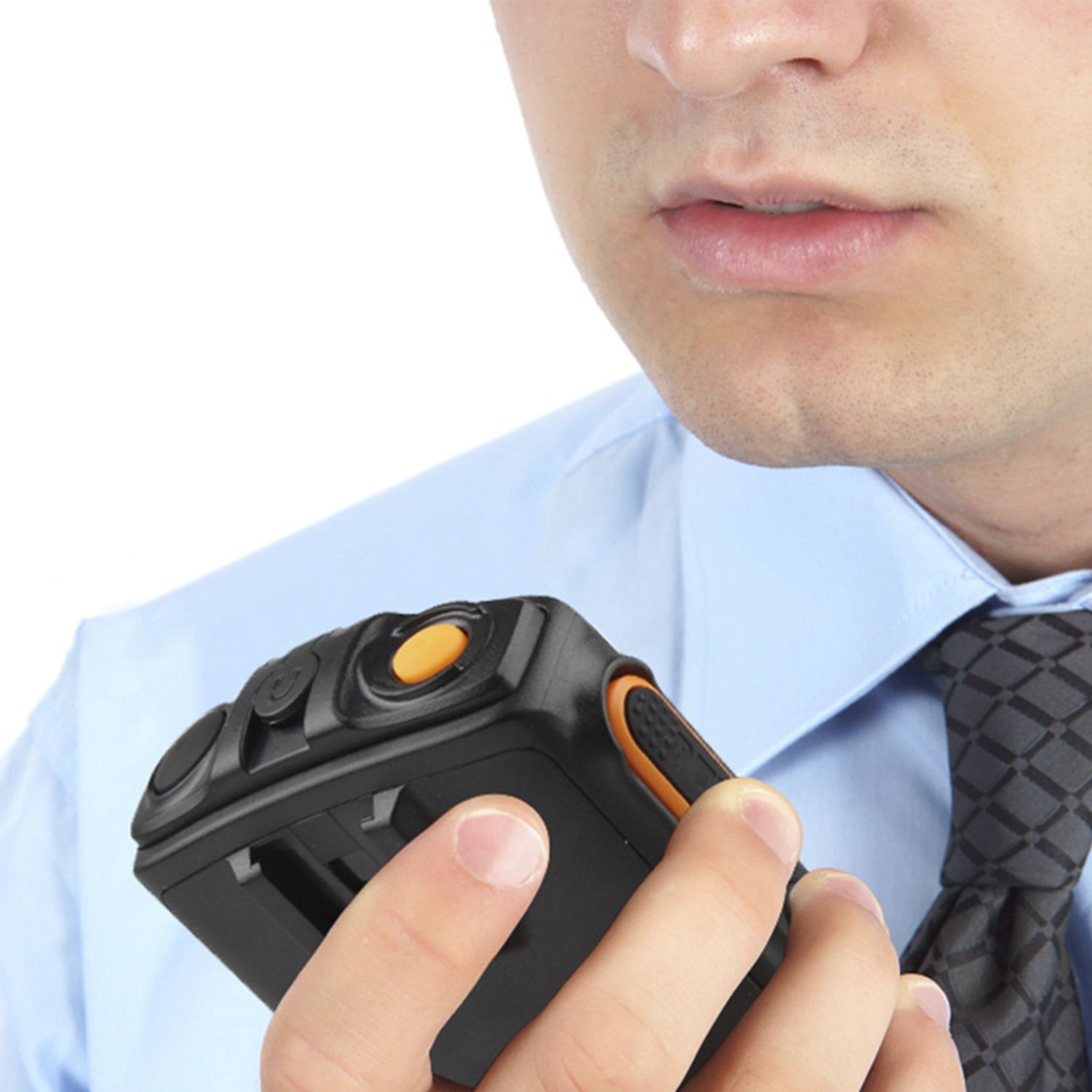 Primer plano de un hombre hablando a un walkie-talkie negro. Botón naranja visible.