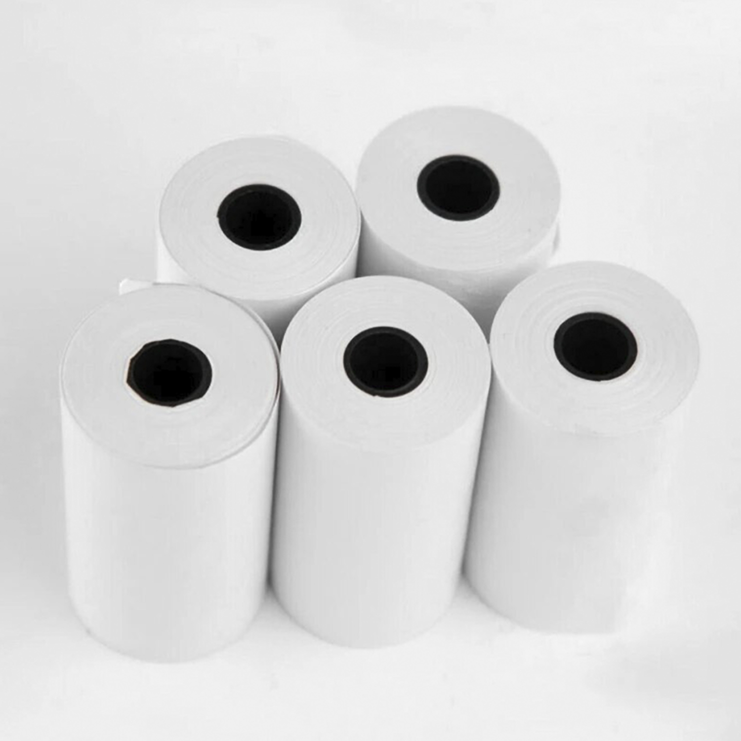 Un grupo de cinco rollos de papel blanco con centros negros, dispuestos sobre una superficie blanca.