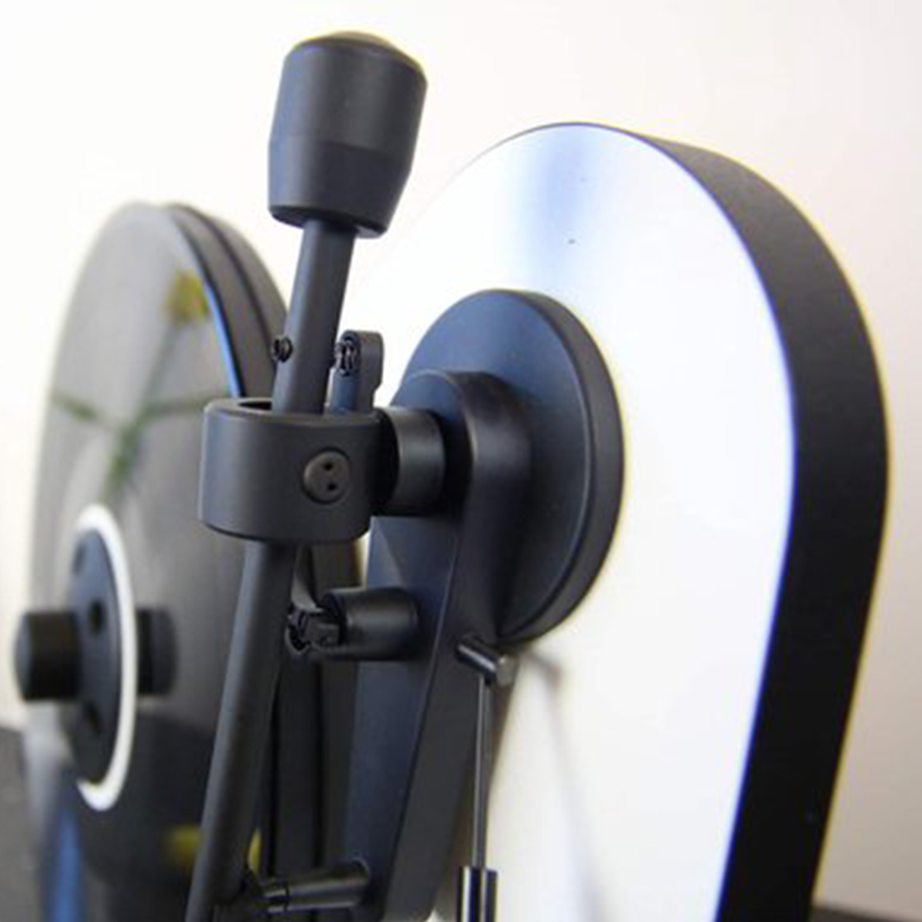 A close-up of a black turntable with a black tone arm.