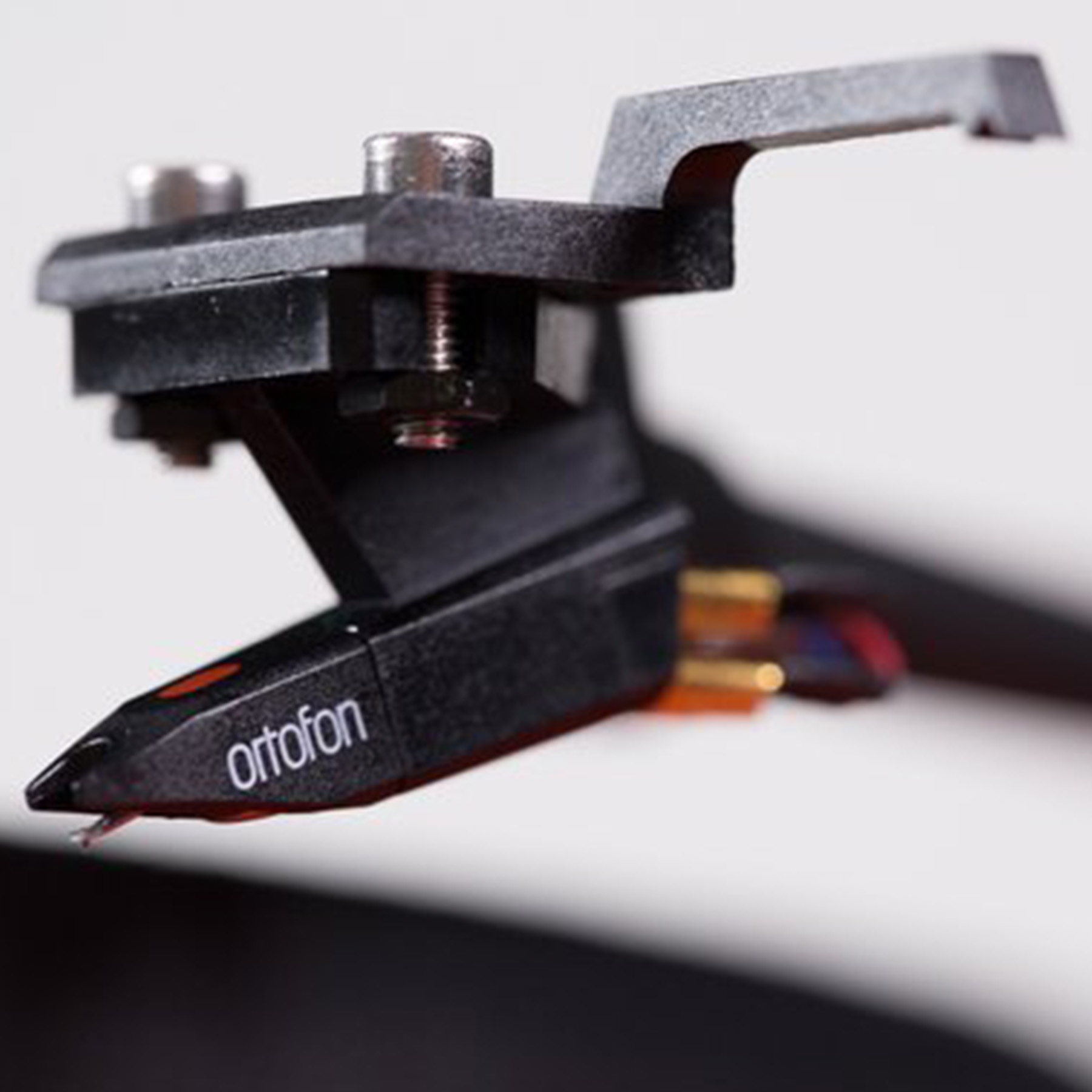 Close-up van een zwarte Ortofon-stylus. De stylus is gemonteerd op een zwarte toonarm.