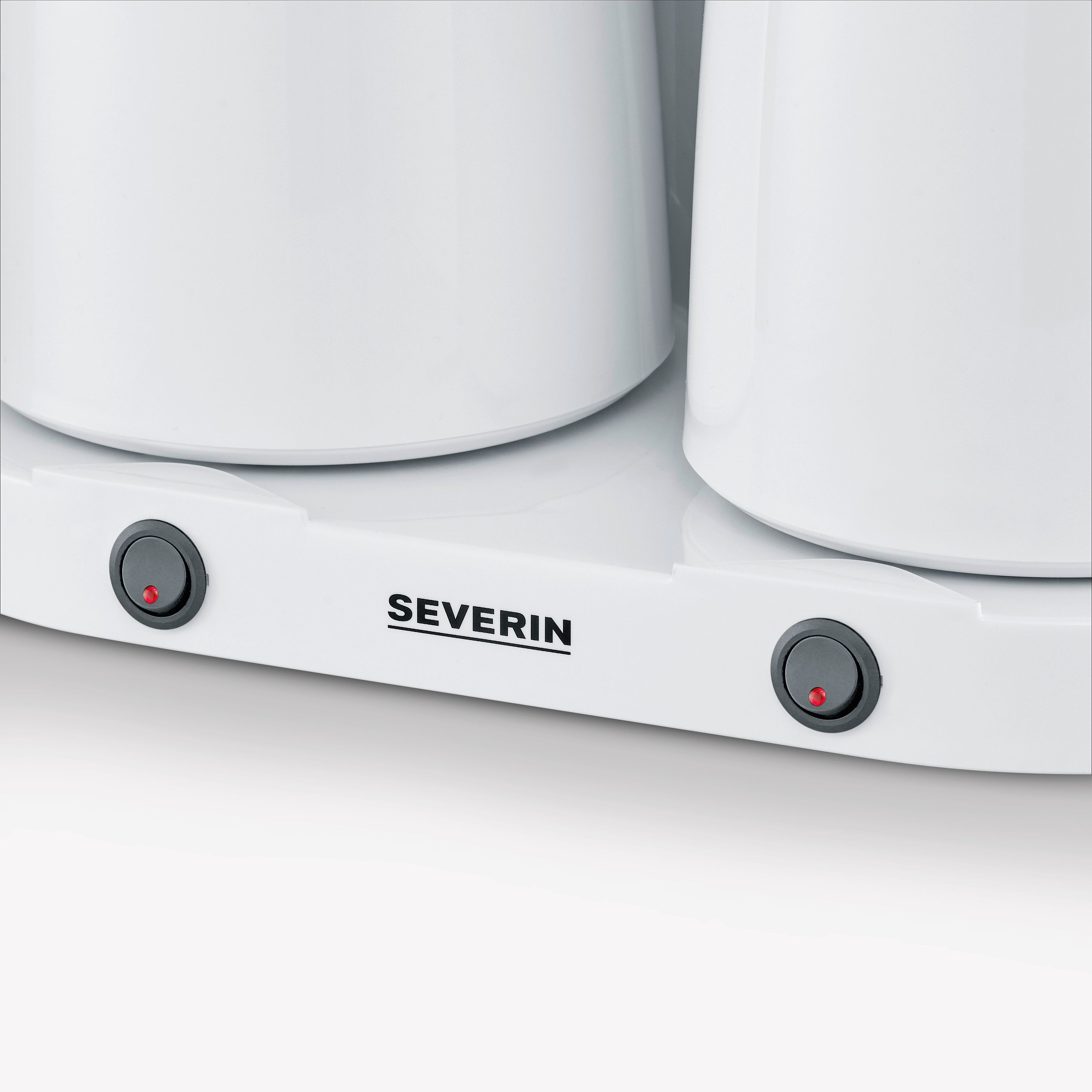 Biała podstawa urządzenia z dwoma czarnymi przyciskami zasilania z czerwonymi światłami.