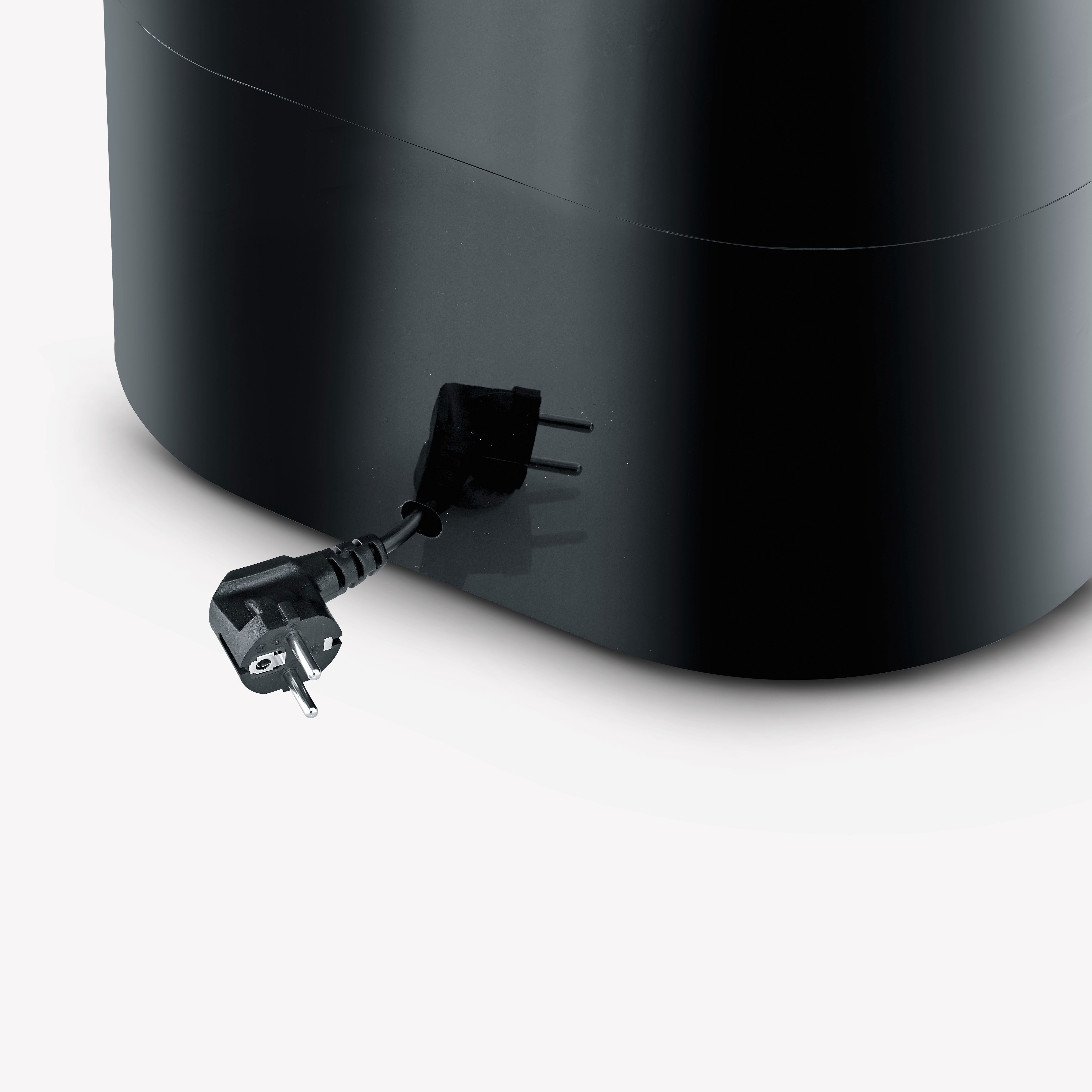 Czarna wtyczka z dołączonym czarnym przewodem zasilającym. Wtyczka jest kątowa i znajduje się na białej powierzchni.