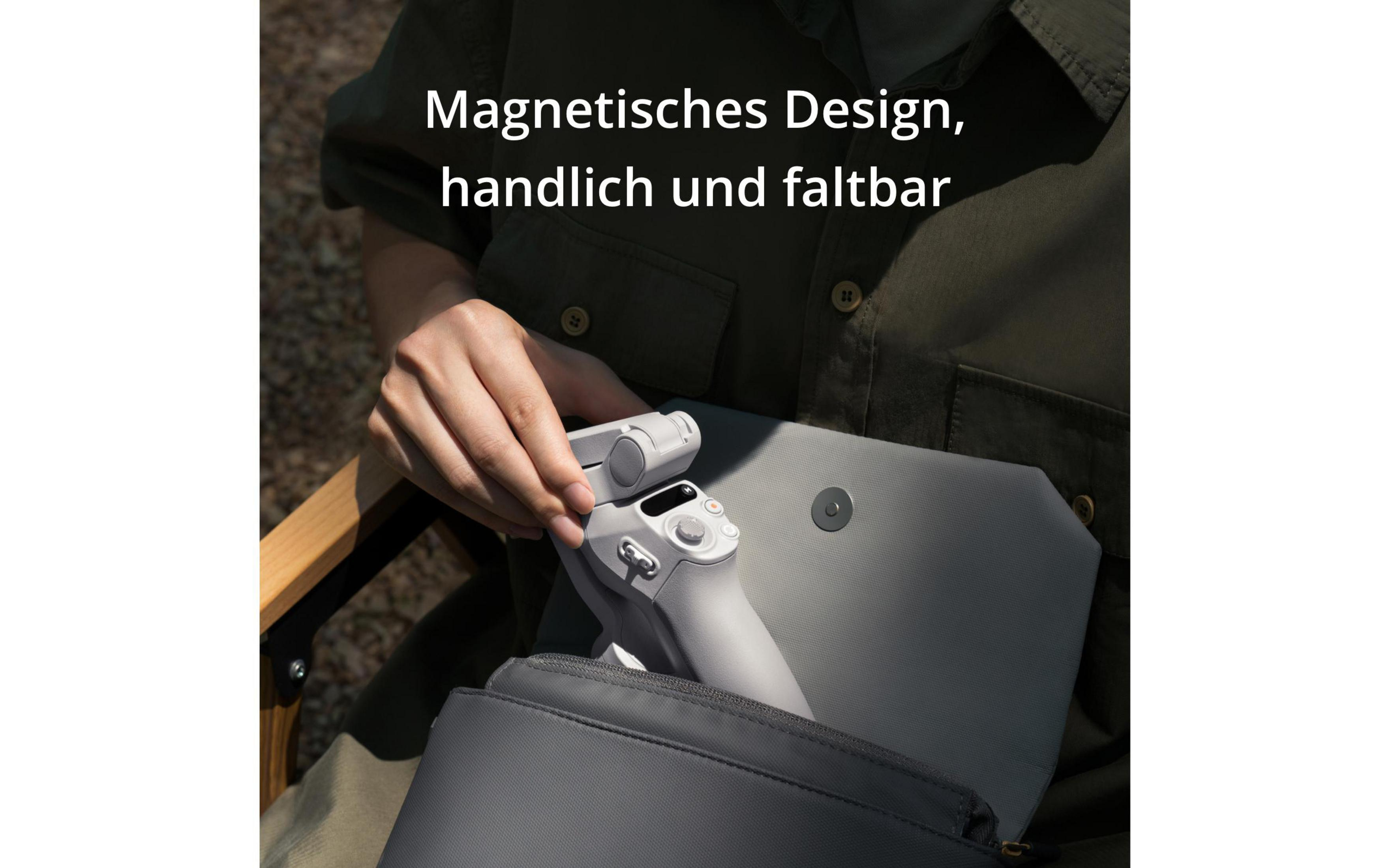 Gri bir çantada gri bir cihaz tutan bir el. Metin manyetik ve katlanabilir diyor.