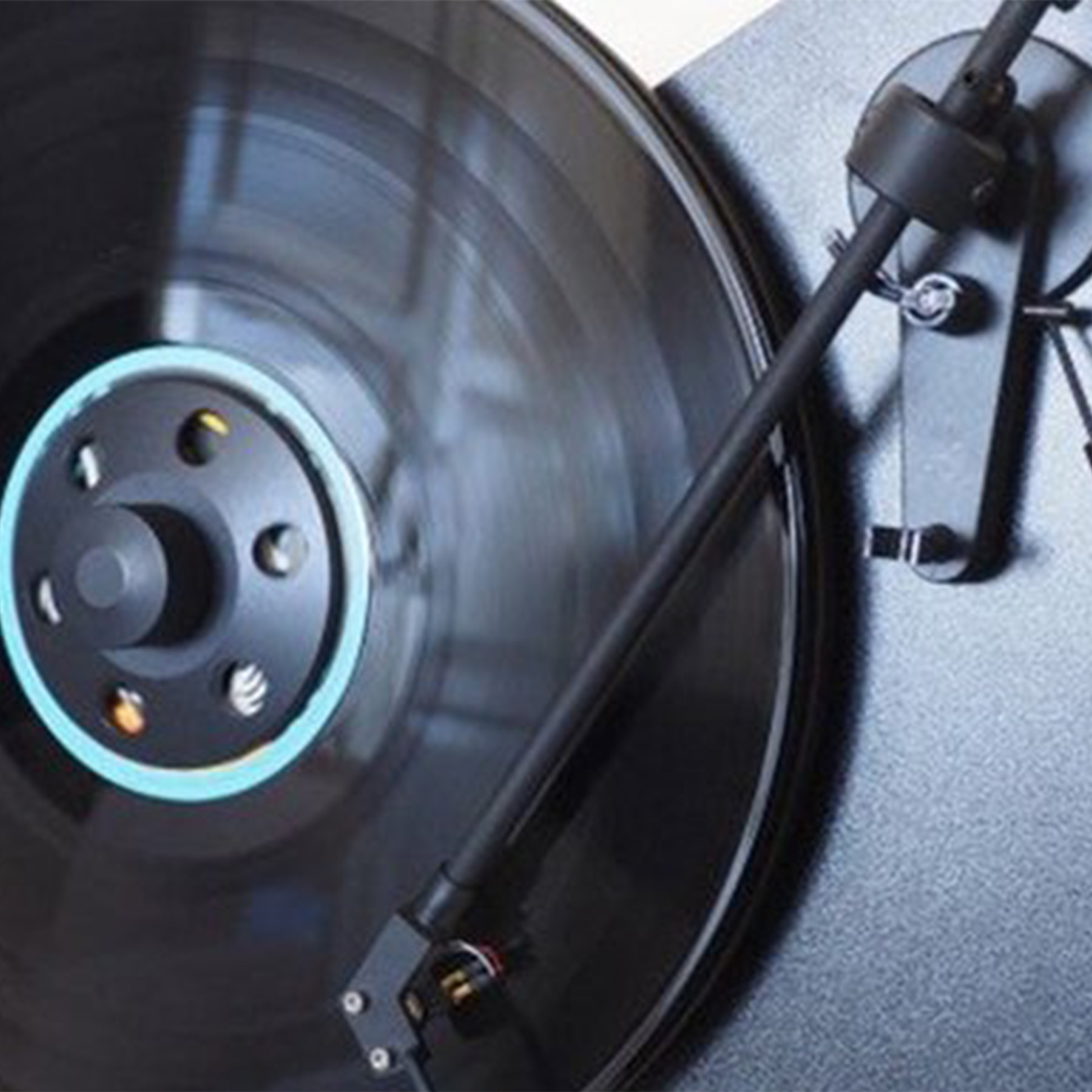 Vinile su giradischi, primo piano. Nero e argento.
