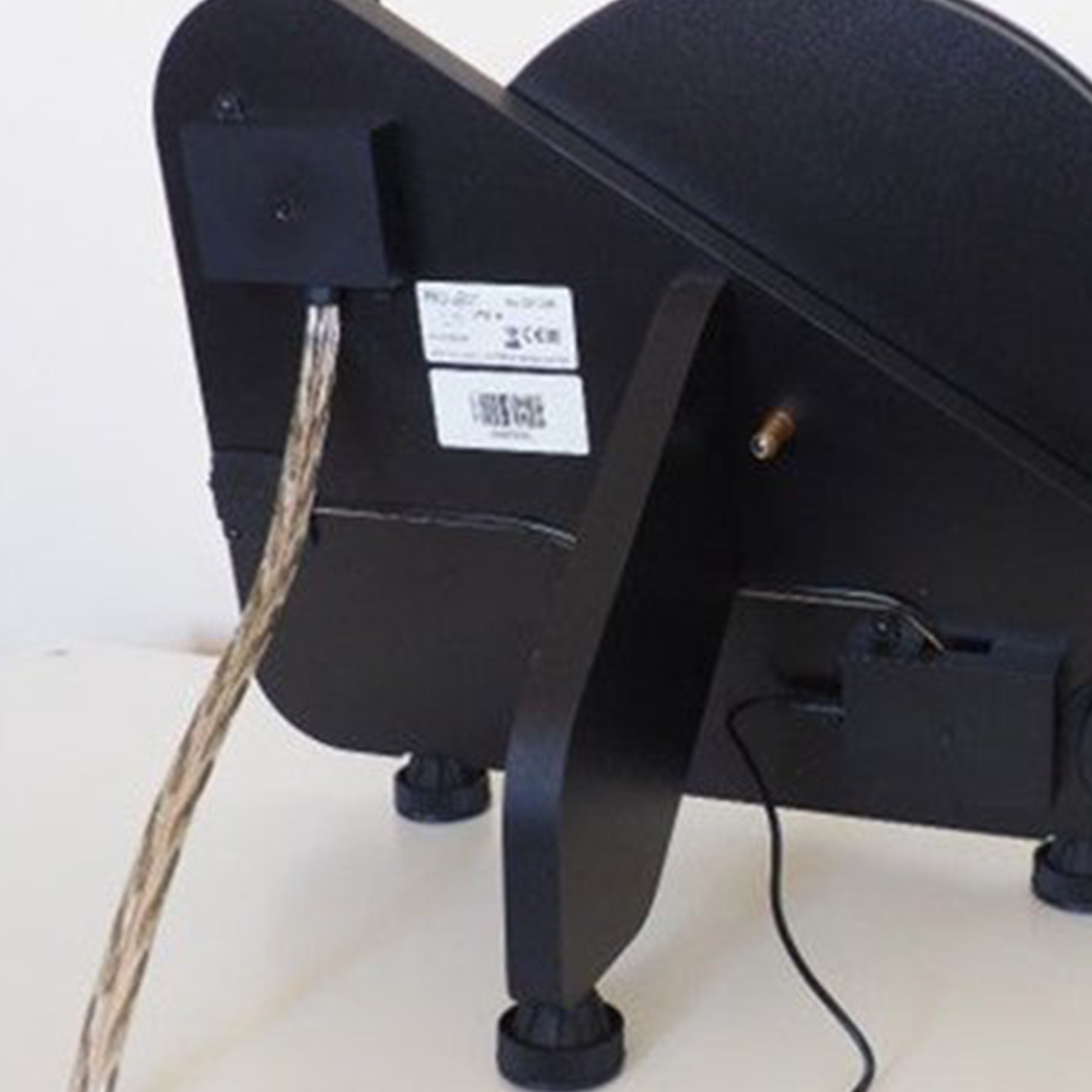 Dispositivo audio nero visto da dietro. Il dispositivo è su una superficie bianca.