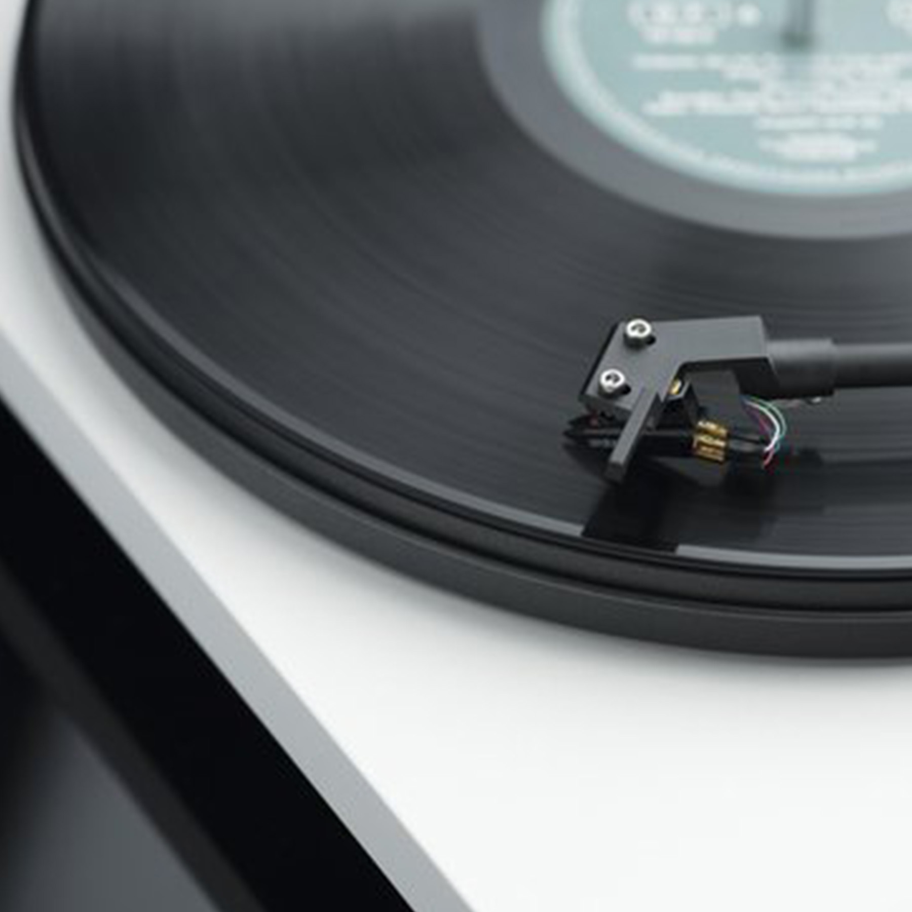 Primo piano di un giradischi con disco in vinile nero.