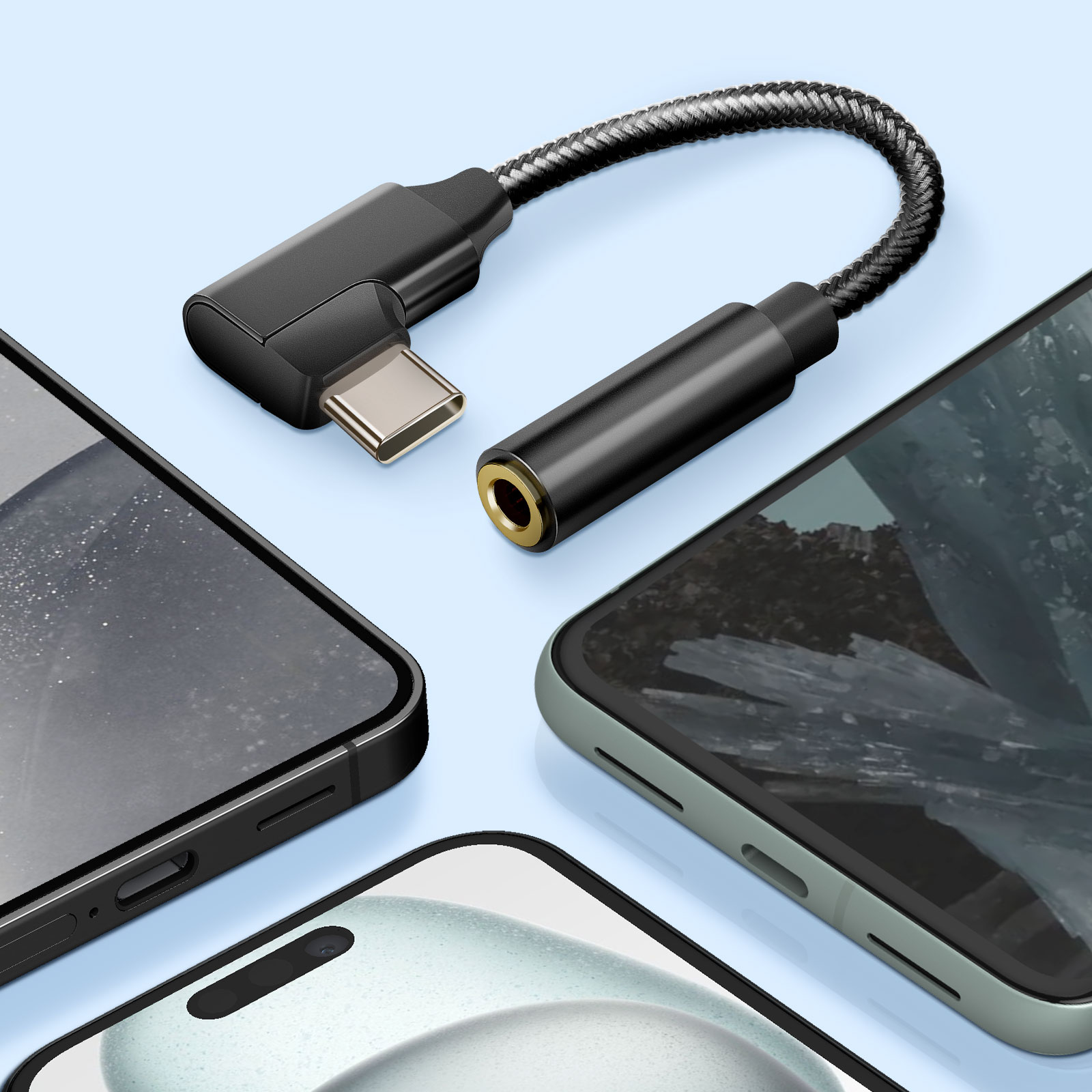 Un adaptador de audio USB-C a 3,5 mm negro conectado a tres teléfonos sobre una superficie azul.