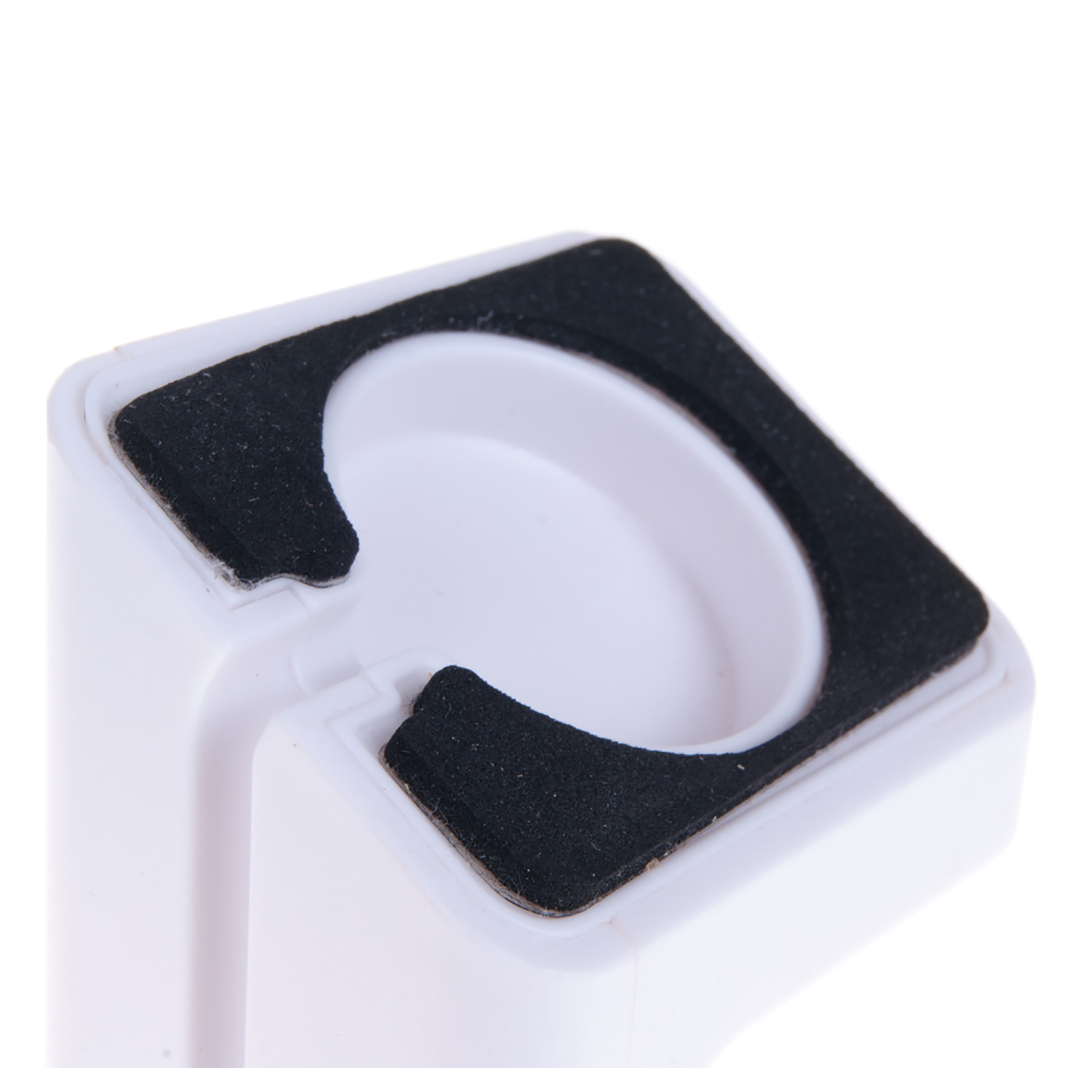 Un dispositivo de plástico blanco con una abertura circular y almohadillas de goma negras.