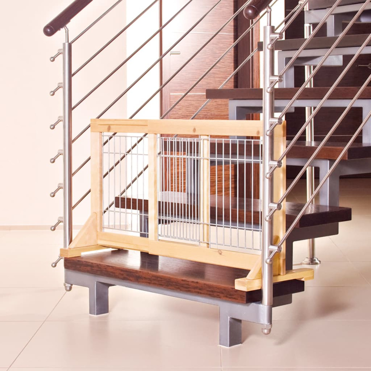 Ein hölzernes Babygitter an einer Treppe mit metallenem Handlauf installiert.