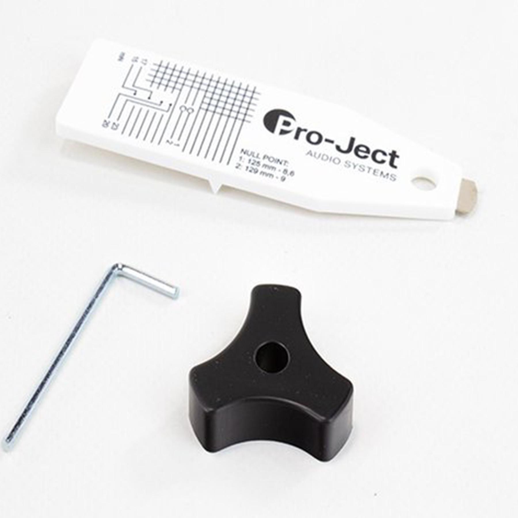Weißes Pro-Ject Tonabnehmer-Ausrichtungswerkzeug, Schraubenschlüssel und schwarzer Einstellknopf.