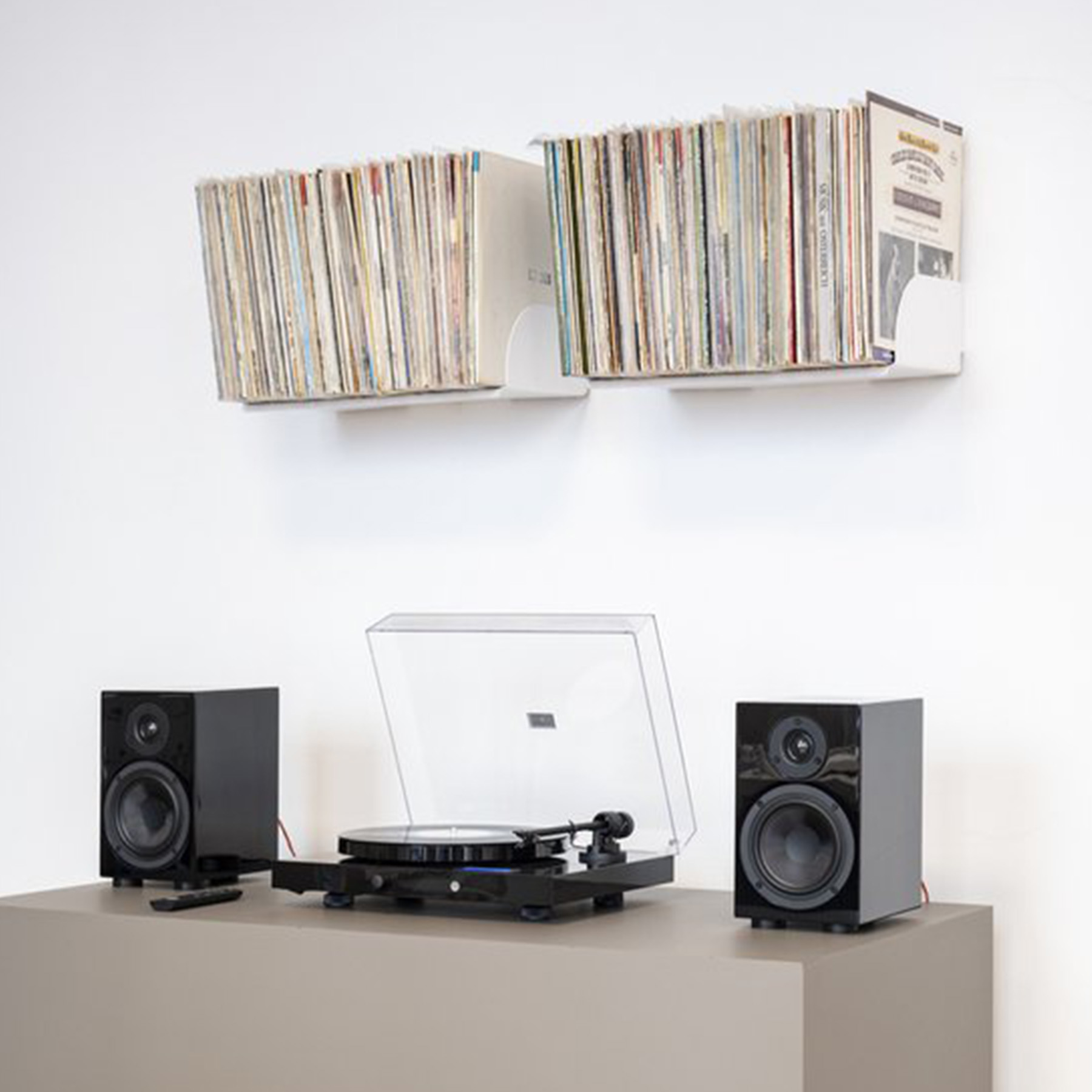 Gramofon, głośniki i płyty winylowe na szarej powierzchni.