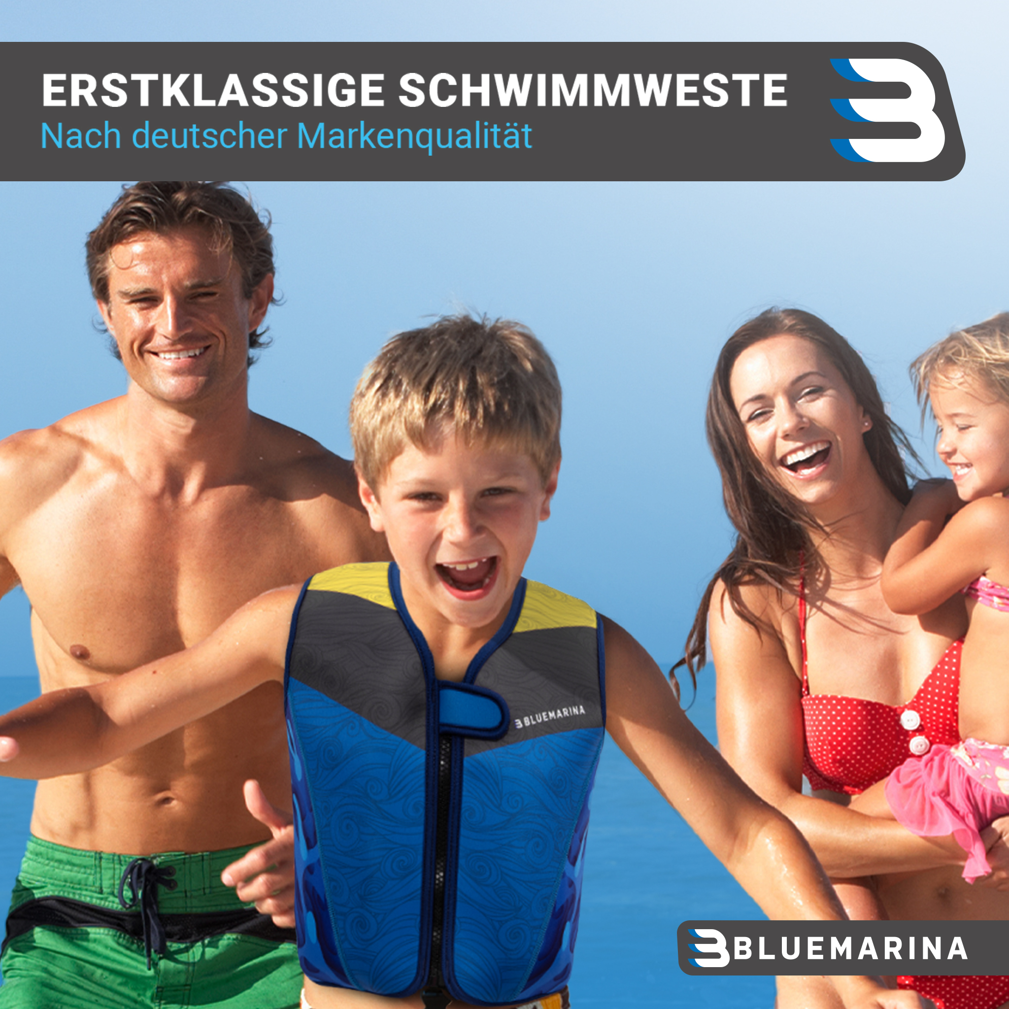 Familie am Strand, trägt Schwimmwesten. Besteht aus zwei Eltern und zwei Kindern, glücklich und lächelnd.