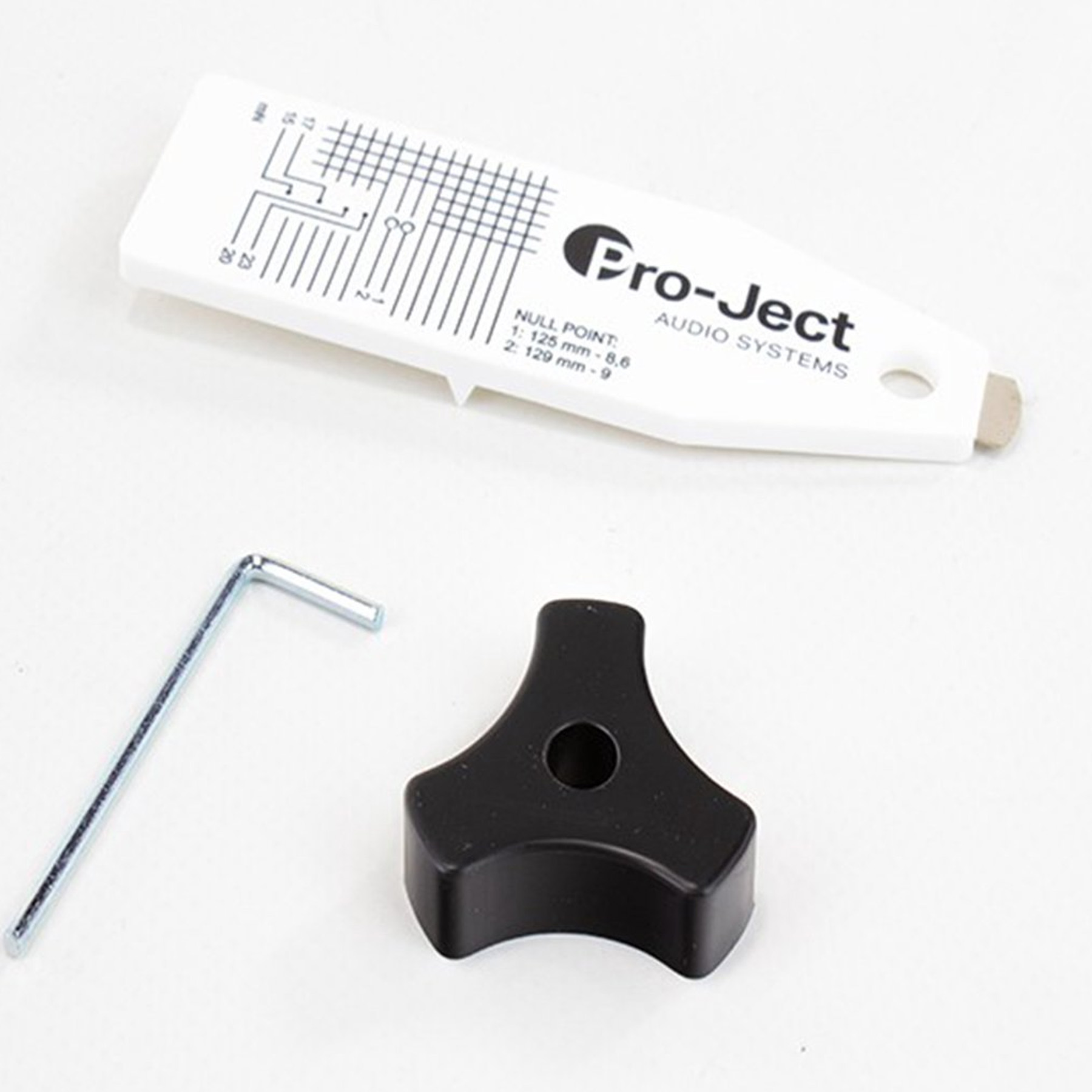 Weiße Pro-ject Werkzeugsatz-Komponenten. Enthält ein weißes Werkzeug, ein schwarzes Teil und einen Metallschlüssel.