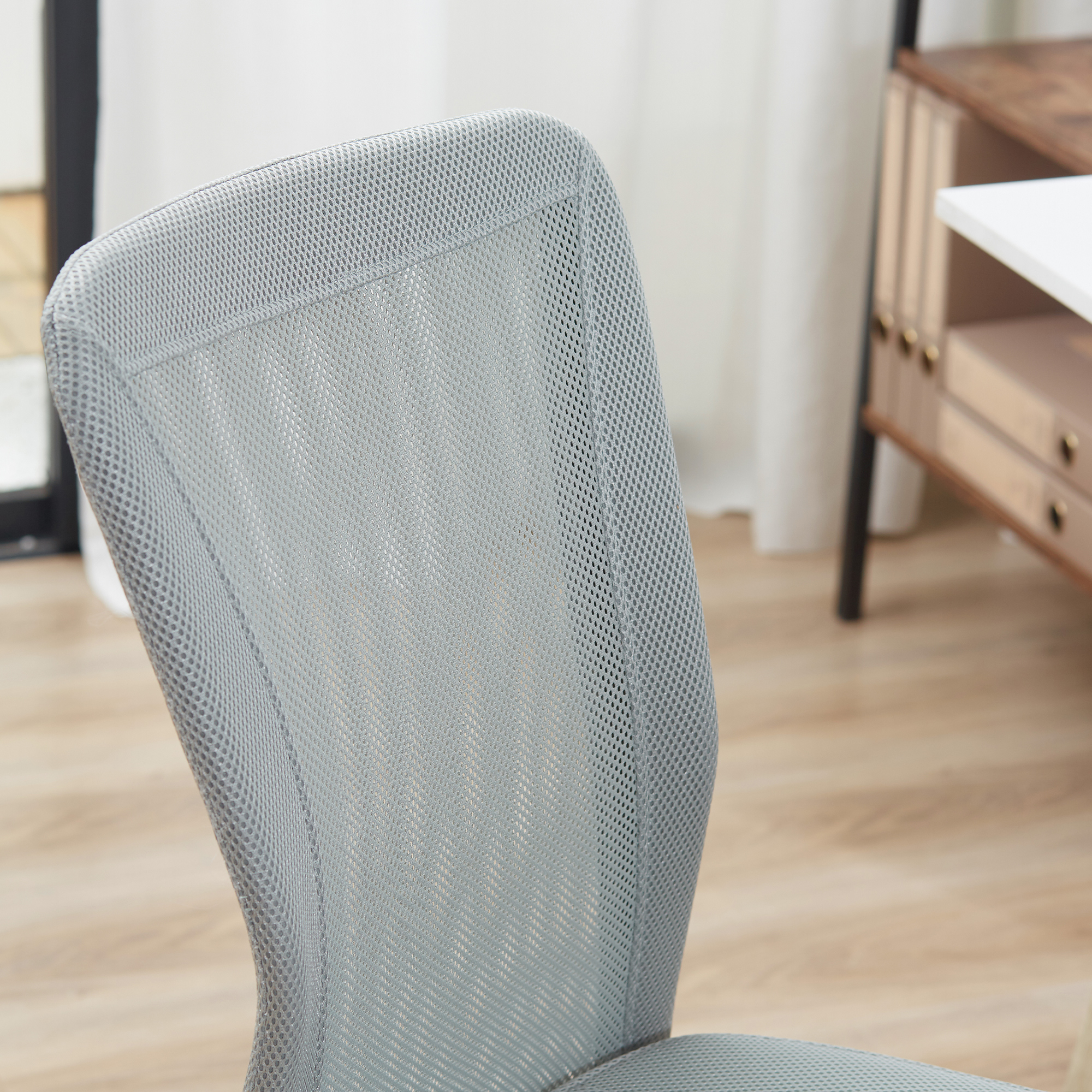 Primer plano de una silla de oficina gris. Respaldo y asiento de malla.