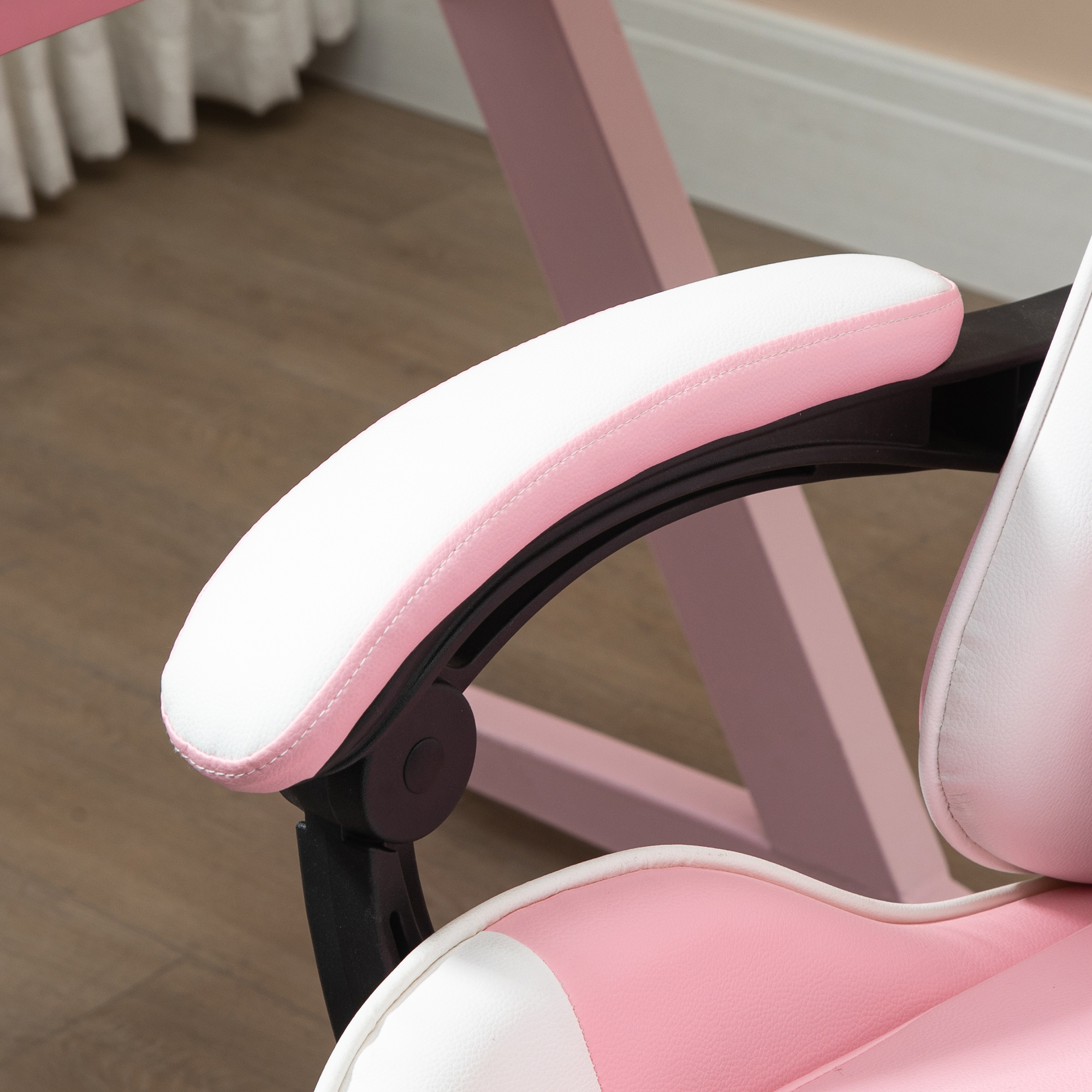 Primer plano de un reposabrazos de silla gamer rosa y blanco, con un soporte negro.