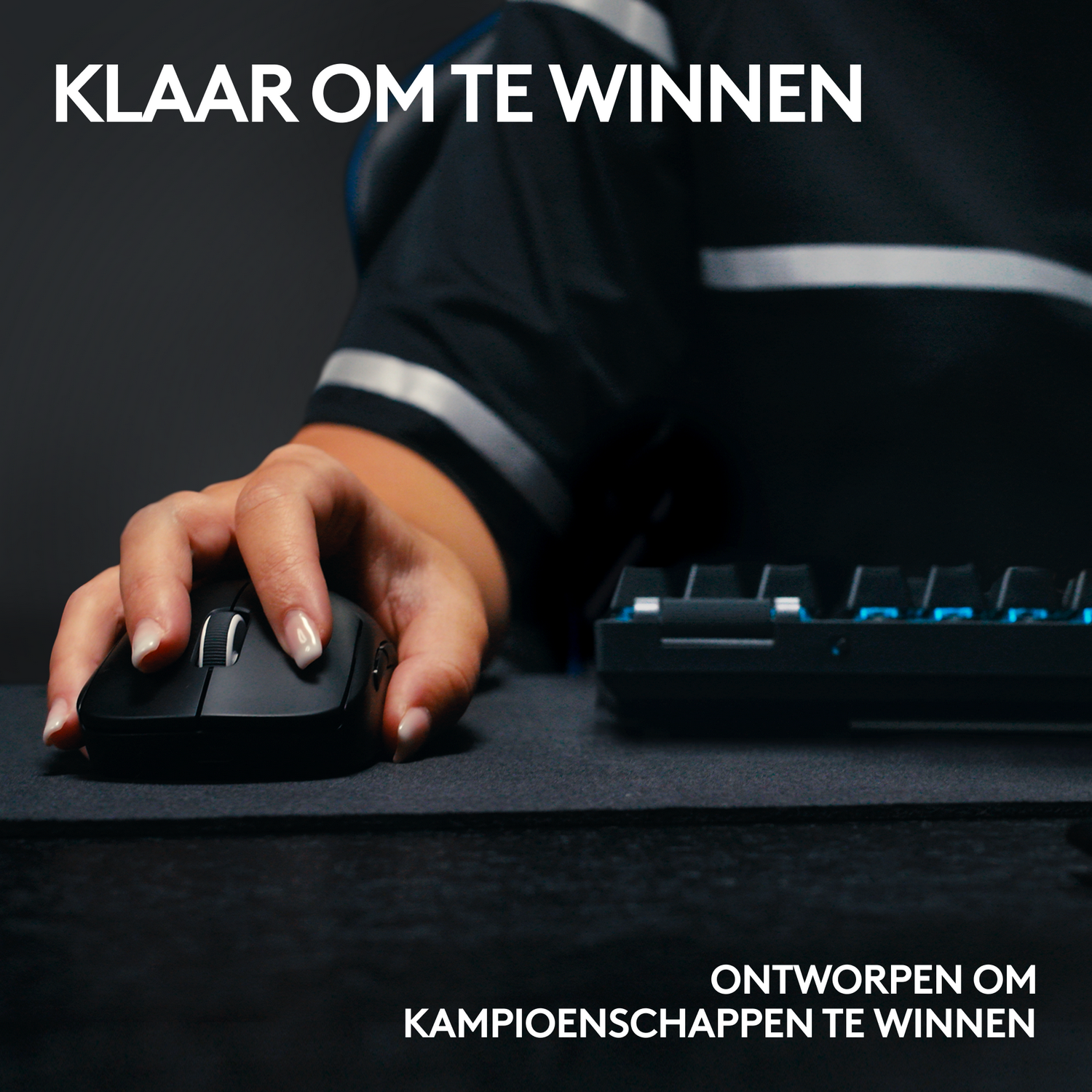 Dłoń osoby używającej czarnej myszy z czarną podkładką i klawiaturą.