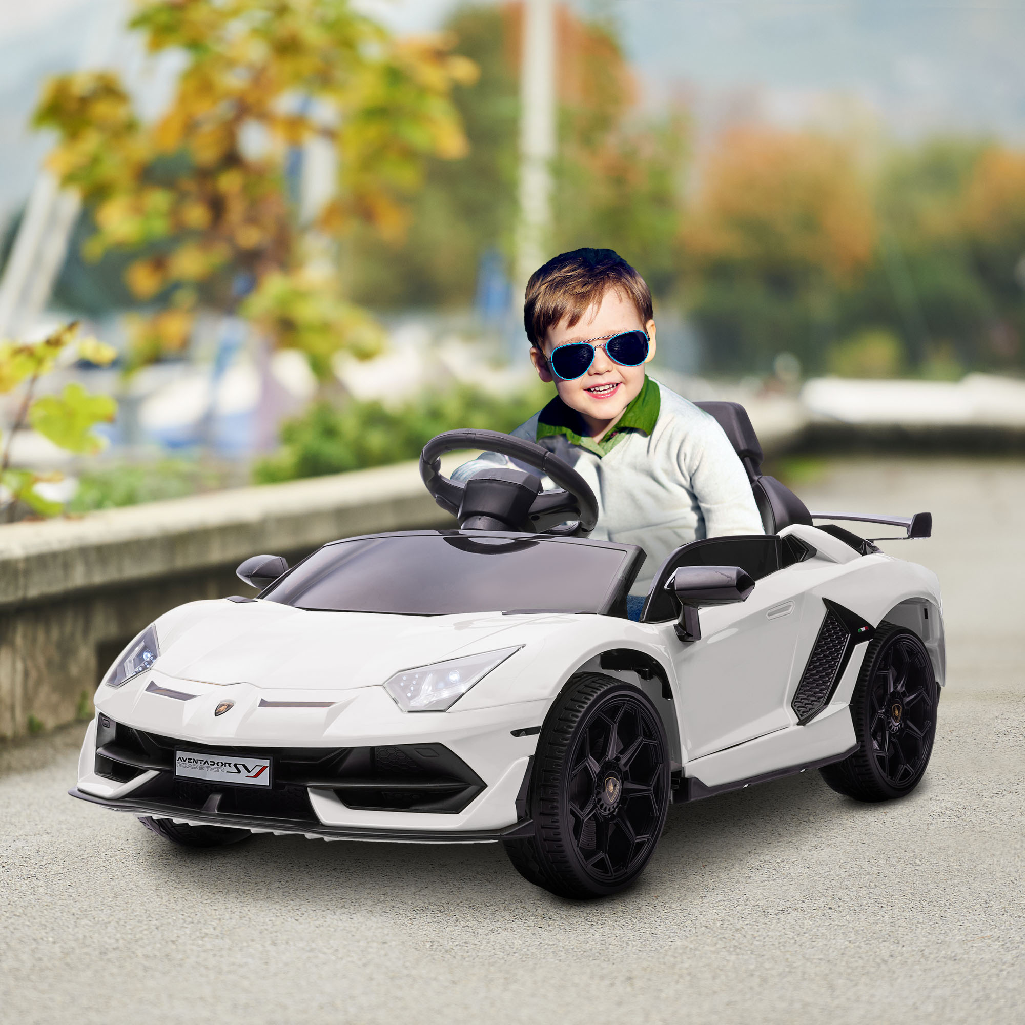 Un niño en un coche de juguete blanco con gafas de sol. El coche es blanco.