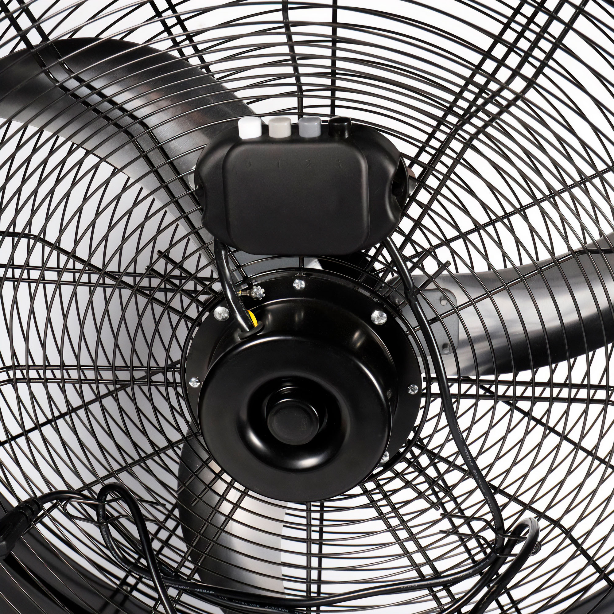 Primer plano de un ventilador industrial negro con malla protectora. Se ven las aspas, el motor y el panel de control.