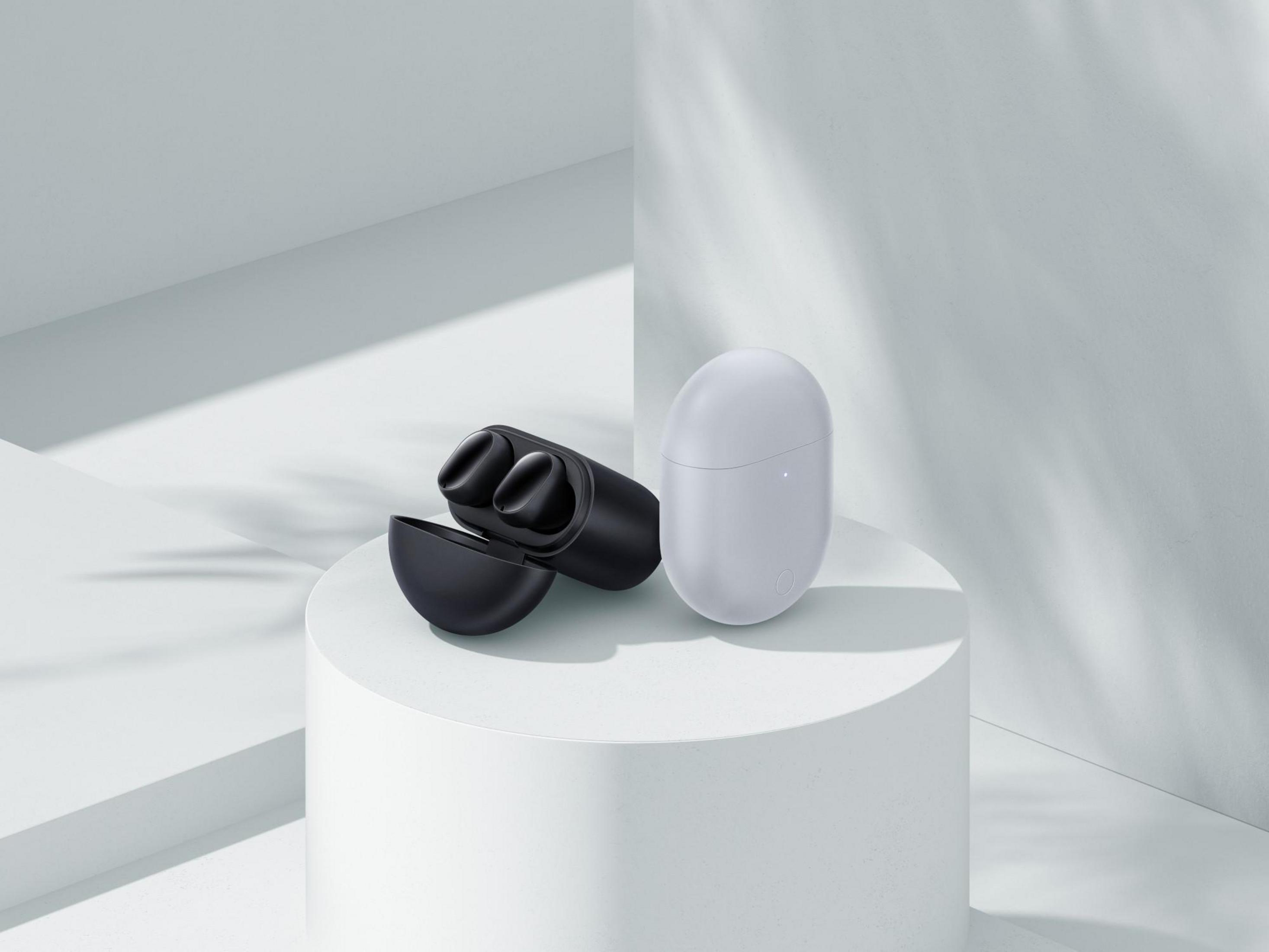 Auriculares y estuche de carga sobre un pedestal blanco, sobre un fondo blanco limpio.