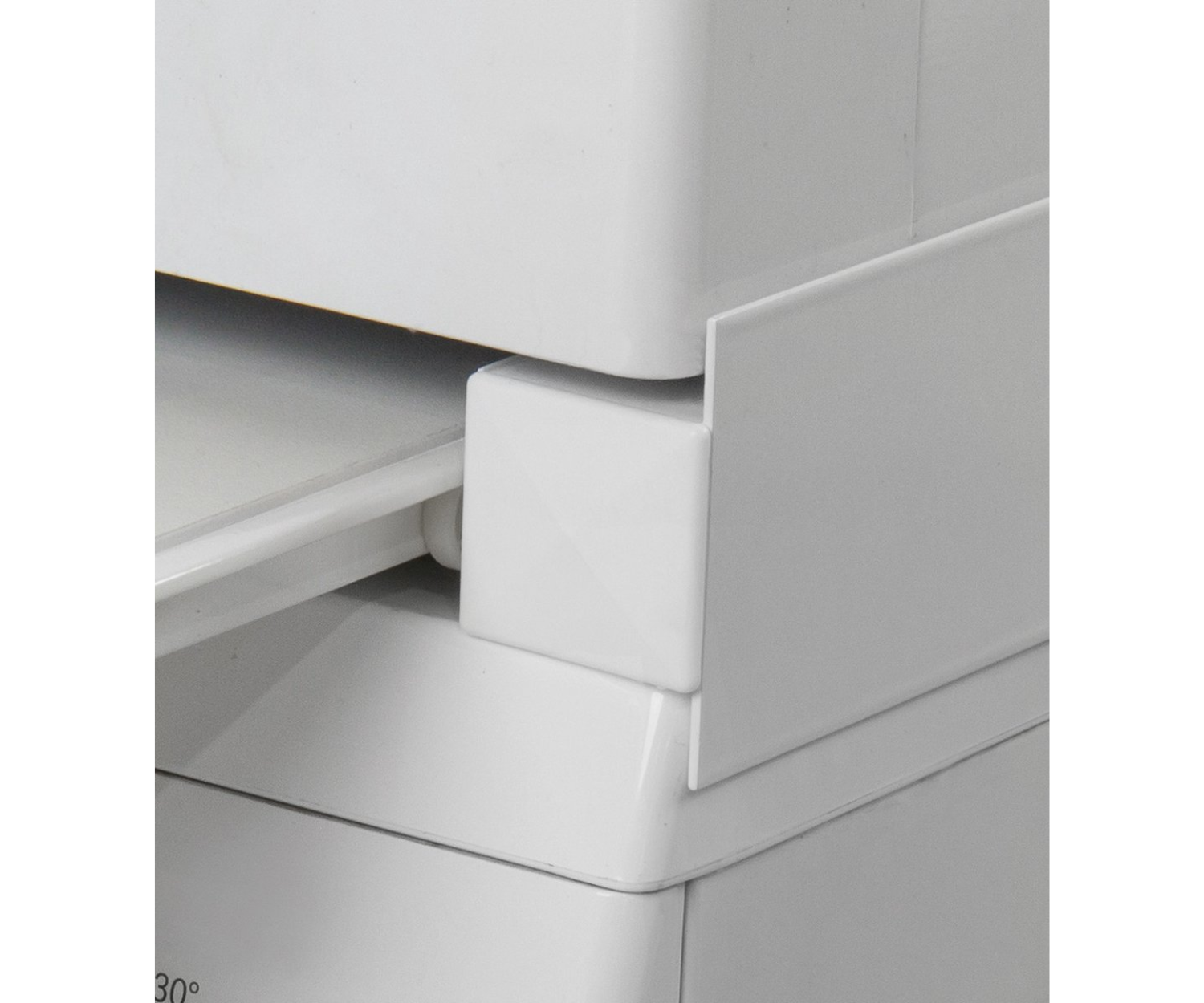 White furniture detail, showing a corner of a cabinet and a shelf.