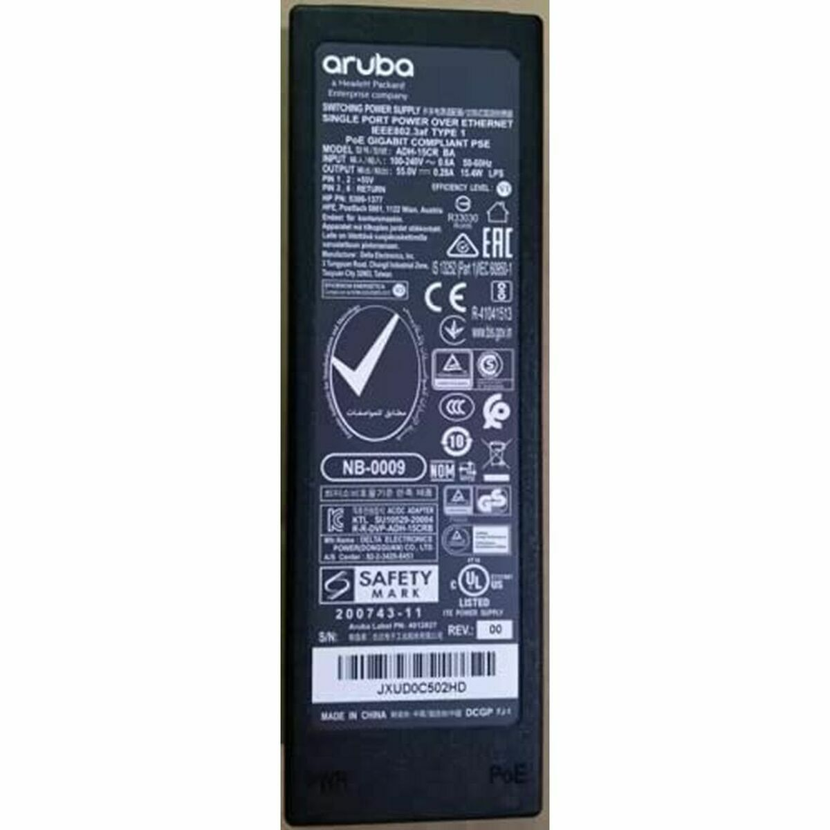 Une alimentation noire avec diverses étiquettes et certifications, y compris le logo Aruba.