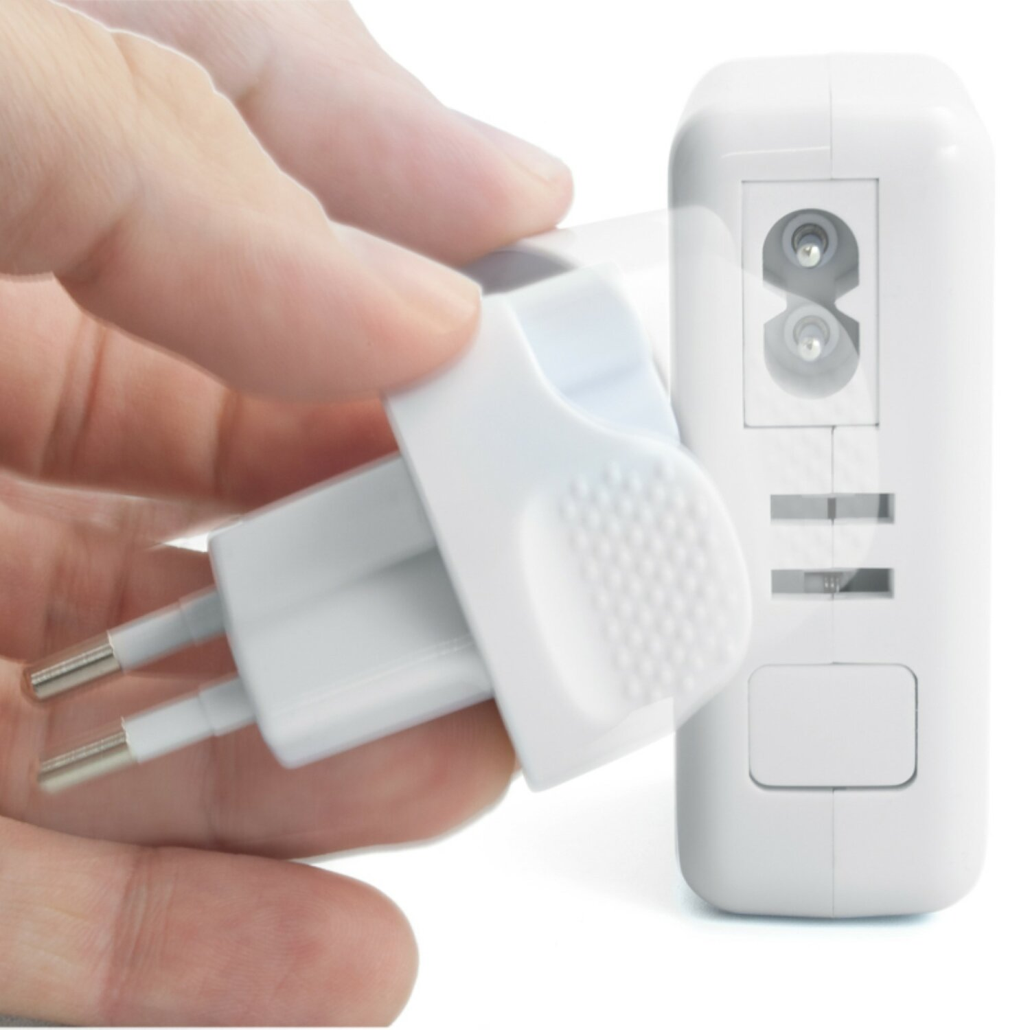 Eine Hand, die einen weißen Adapter in eine weiße Steckdose steckt, wobei der Stecker gezeigt wird.