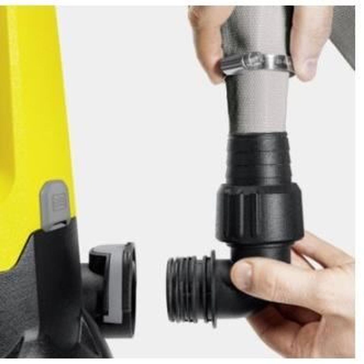 Osoba podłącza wąż do żółtej pompy. Czarny łącznik jest mocowany.