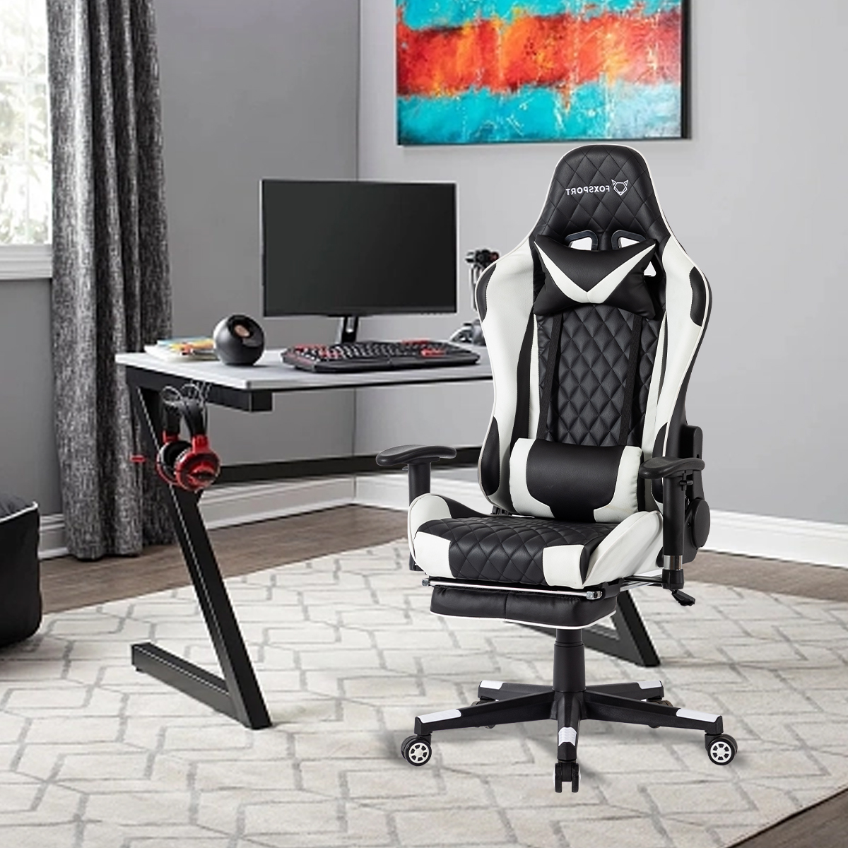 Weißer und schwarzer Gaming-Stuhl in einem Raum mit Schreibtisch, Monitor und Kunstwerk.