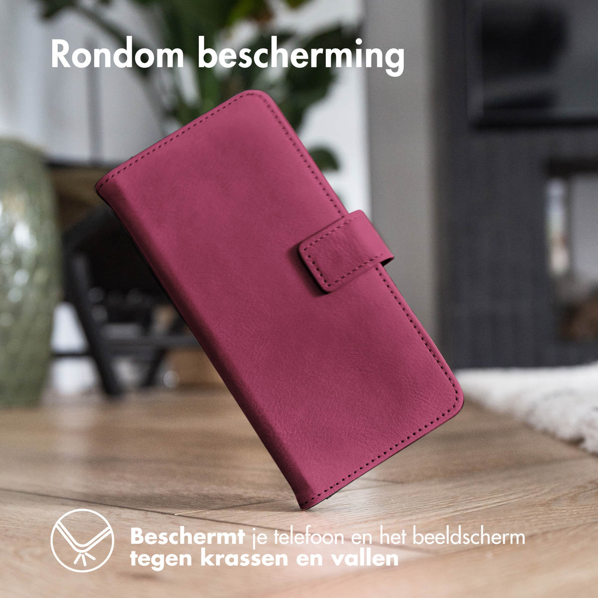 Close-up van een bordeauxrode telefoonhoes met magnetische sluiting, op een houten oppervlak.