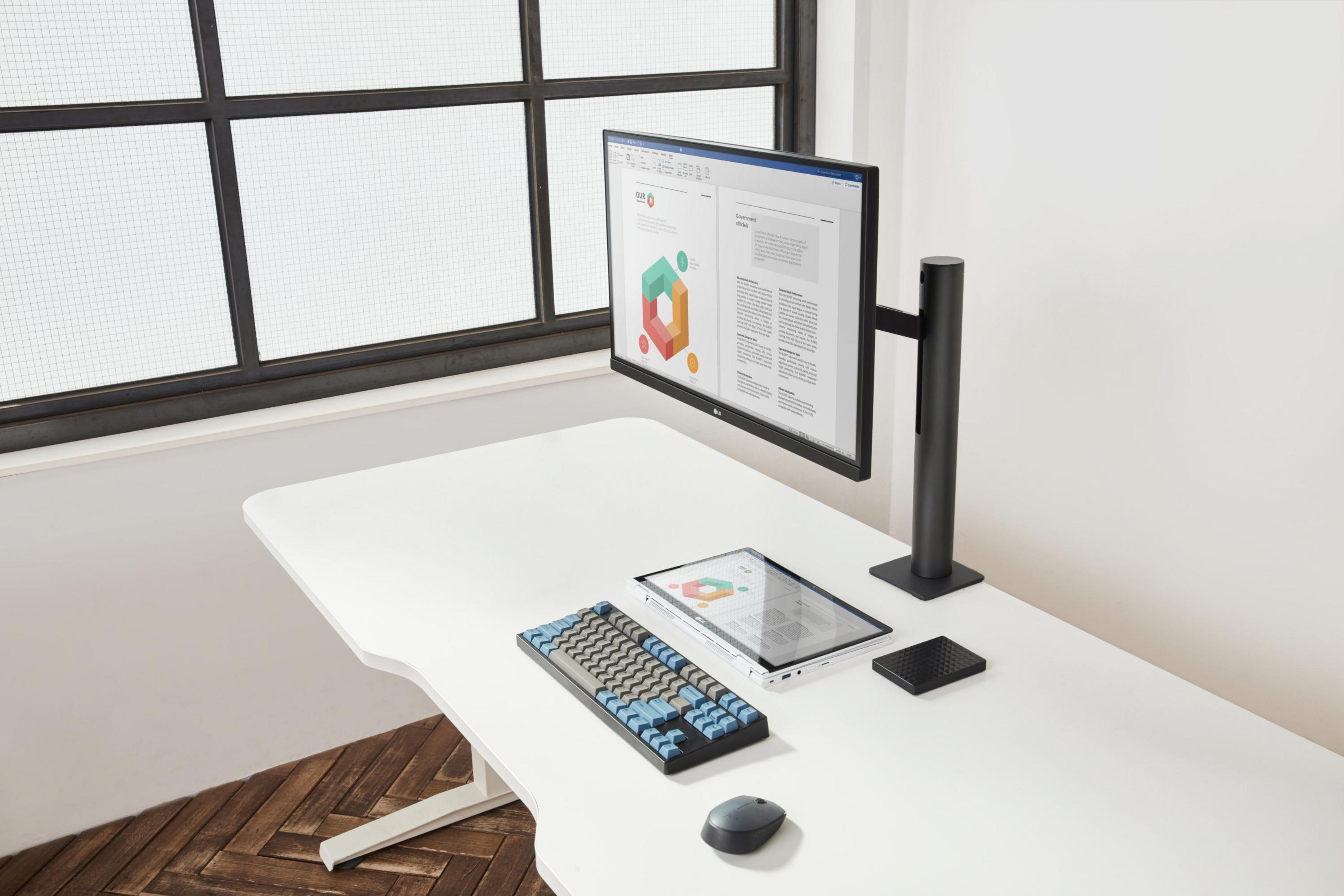 Schreibtisch mit Monitor, Tastatur, Tablet, Maus. Fenster. Dokumente und Diagramme werden angezeigt.