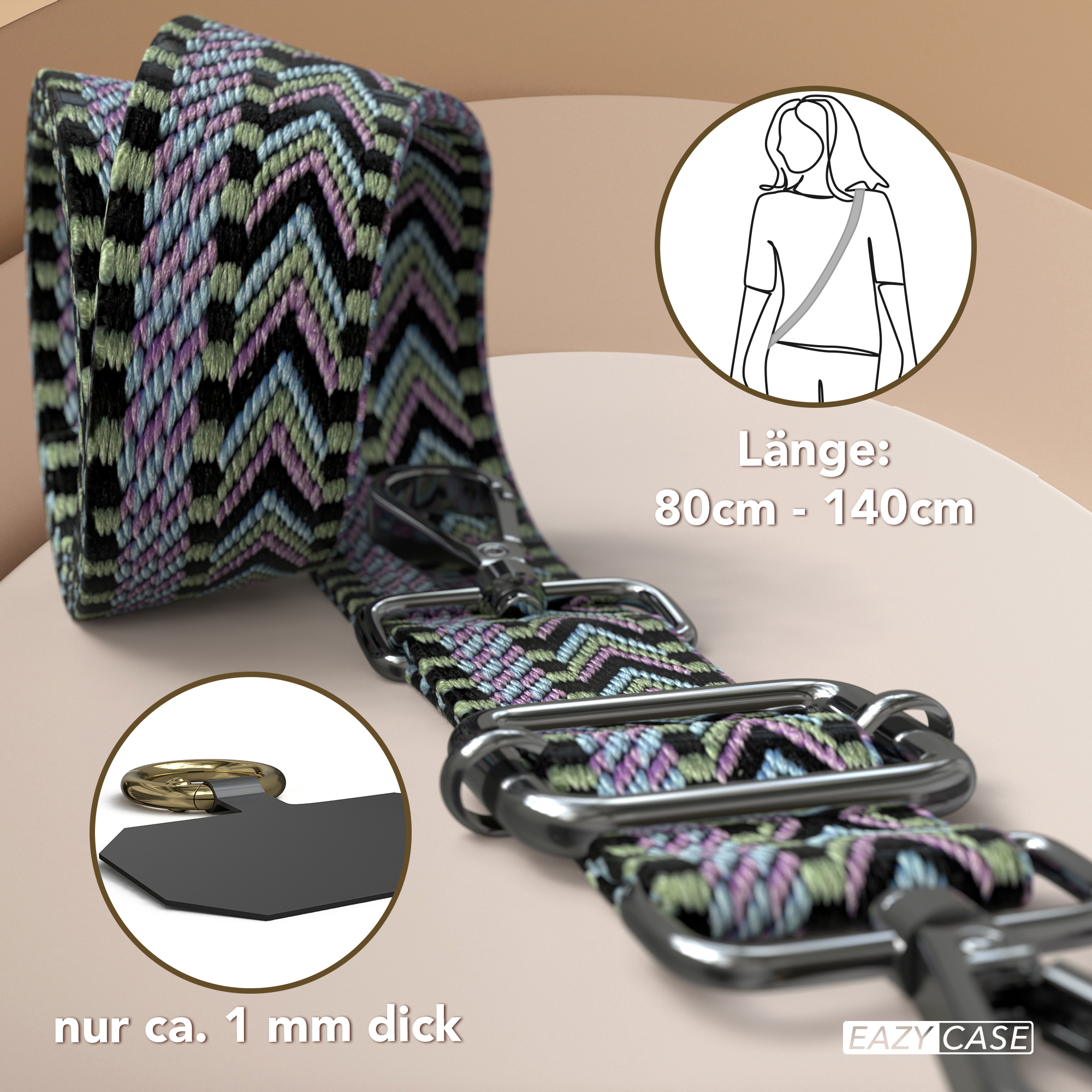 Ein gemusterter Telefonriemen mit Metallverschlüssen und einem schwarzen Anhänger mit Ring, auf grünem Grund.