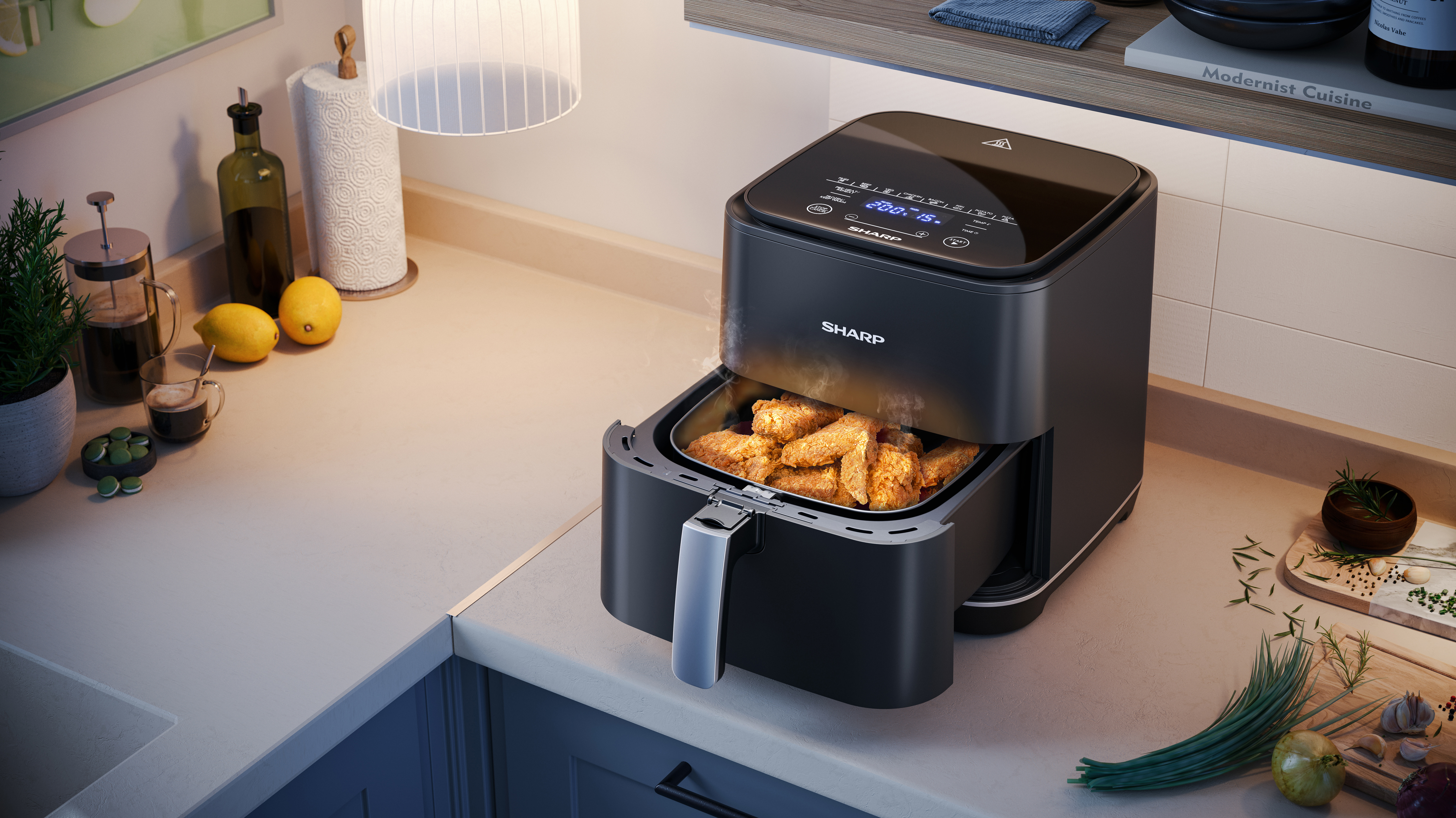 Czarna frytownica powietrzna z kurczakiem, na blacie kuchennym z cytrynami i ręcznikiem papierowym.