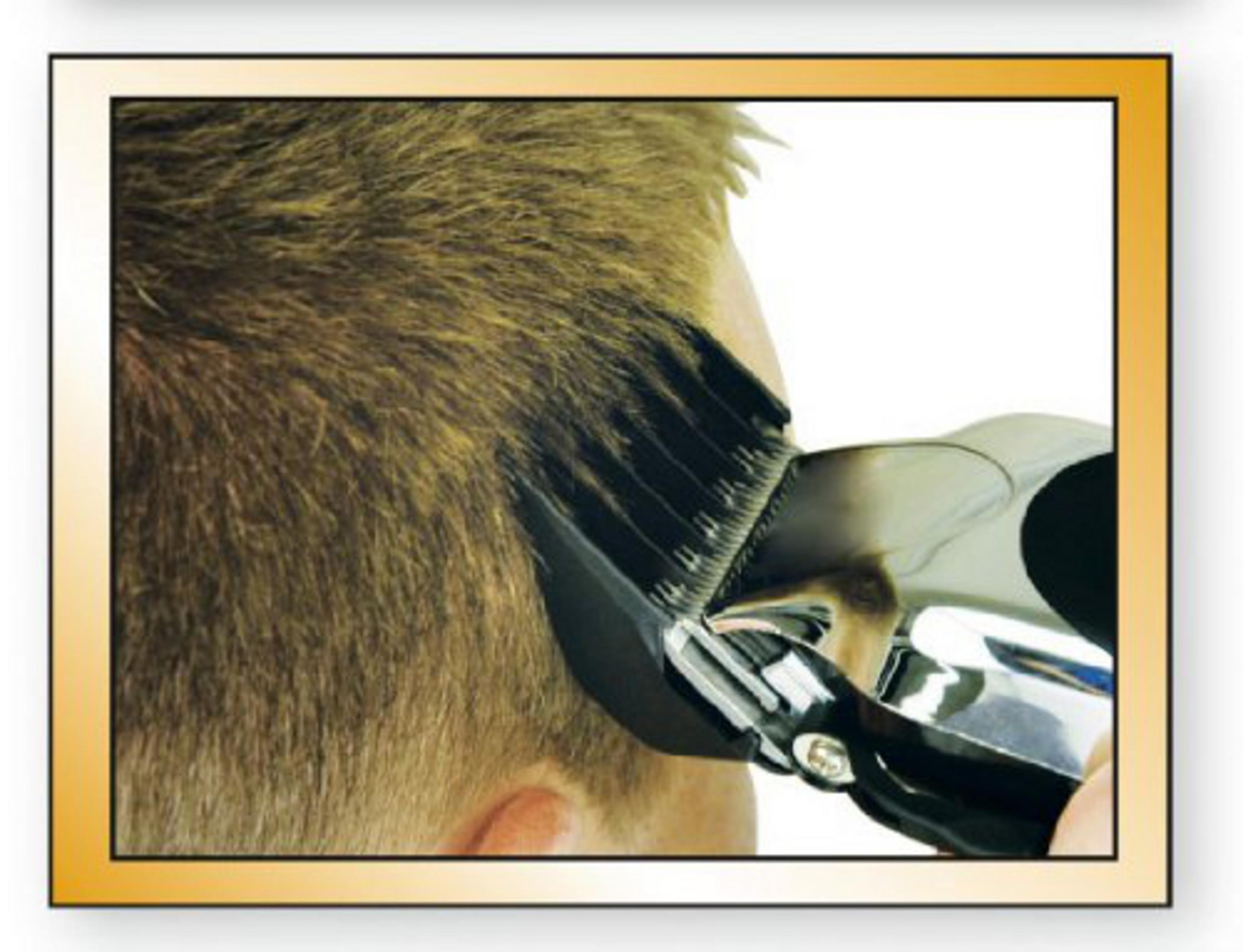 Der Kopf einer Person wird mit einem Haarschneider getrimmt, der Haarschneider ist im Fokus.
