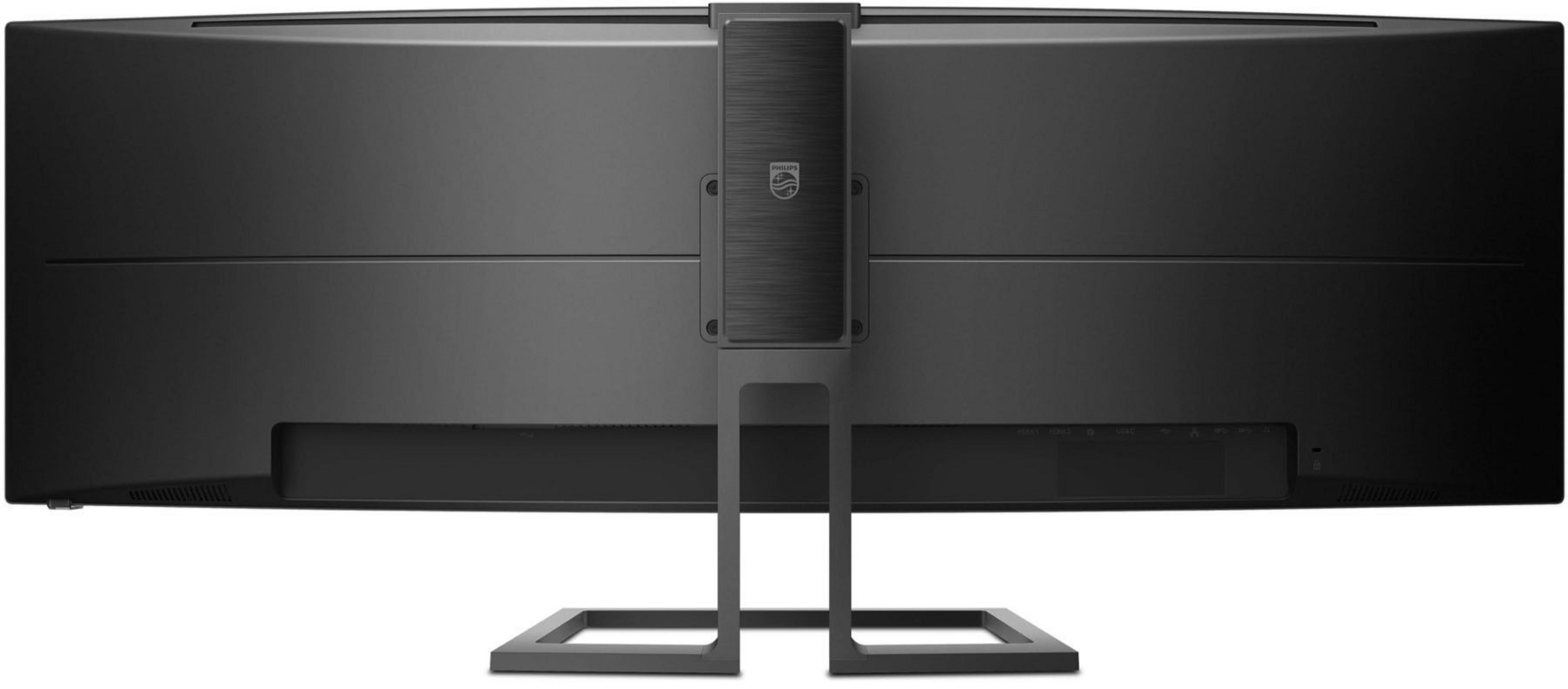 Tył zakrzywionego czarnego monitora ze stojakiem. Logo Philips na stojaku.