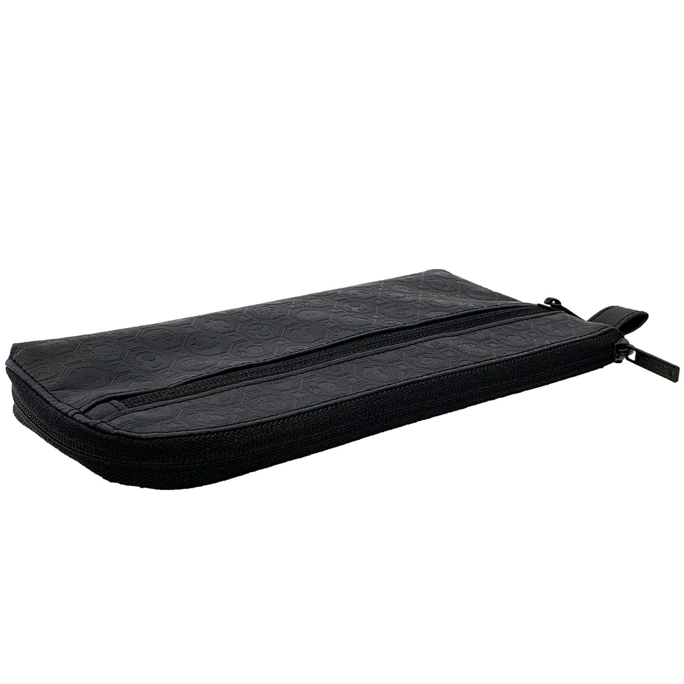 Eine schwarze, mit Reißverschluss versehene Tasche liegt auf einer weißen Oberfläche.