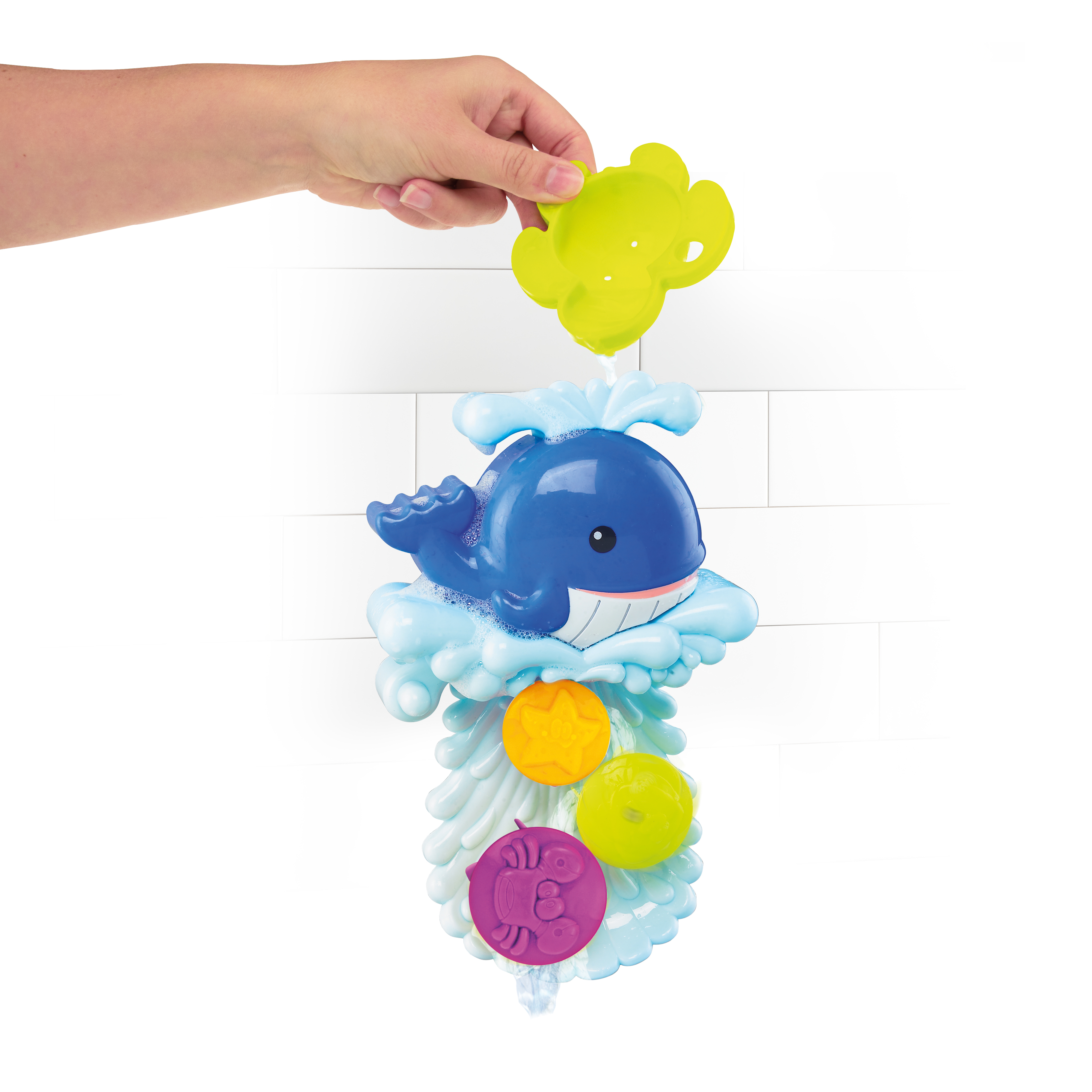 Blaues Wal-Badespielzeug mit Blasen und bunten schwimmenden Spielzeugen, gehalten von einer Hand.